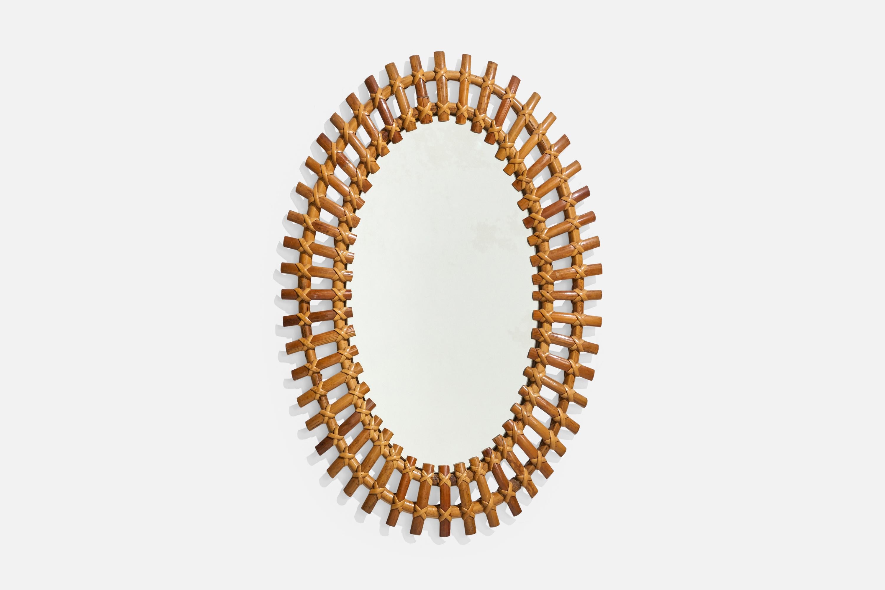 Un miroir mural ovale en rotin conçu et produit par un designer italien, Italie, années 1950-1960.
 