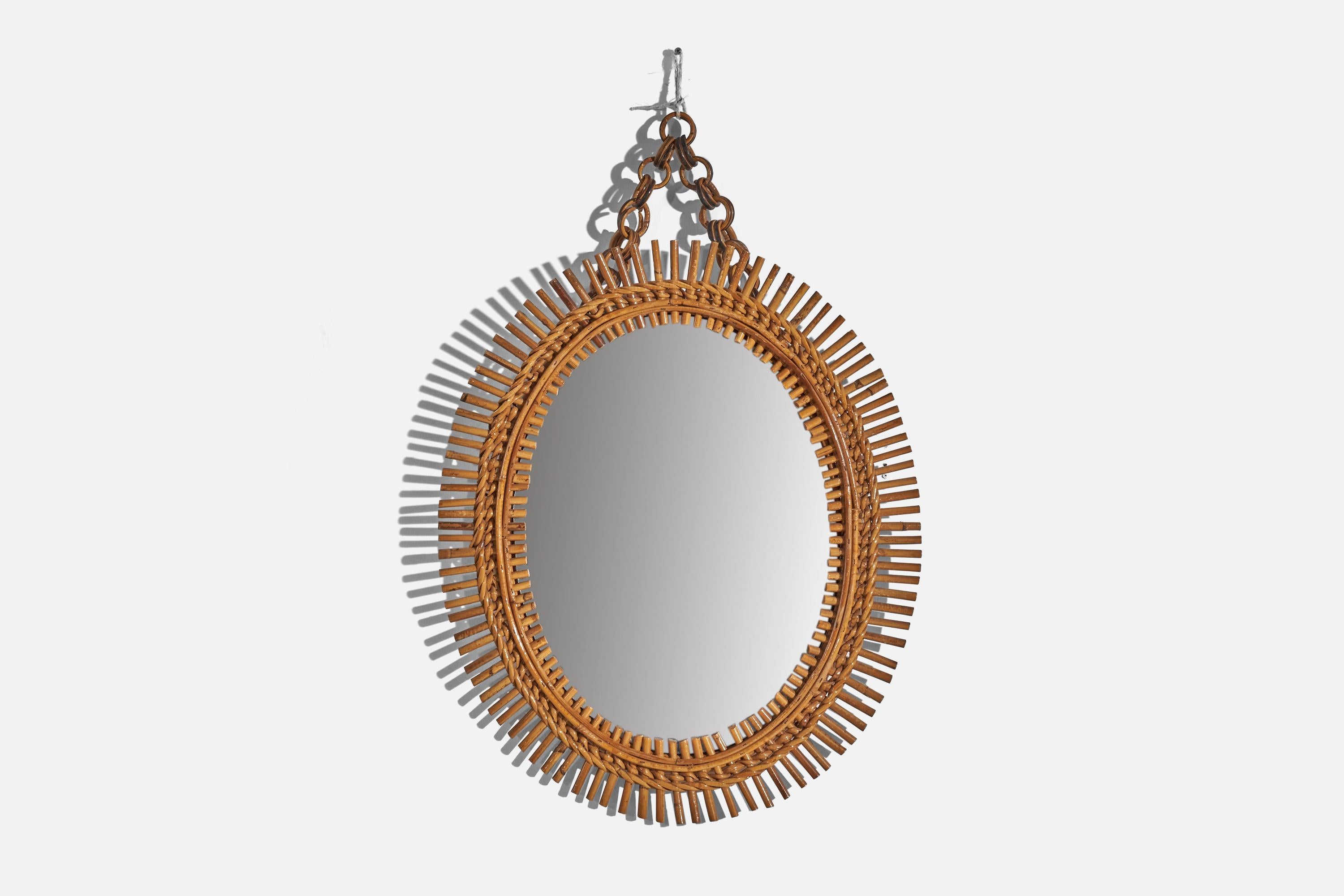 Espejo de pared ovalado, de ratán, diseñado y fabricado por un diseñador italiano, Italia, años 50-60.
 