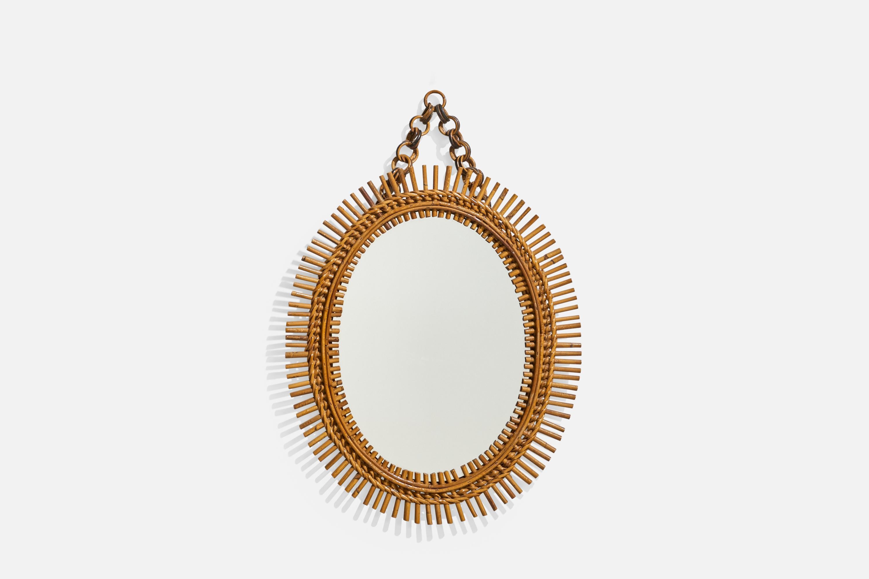 Espejo de pared ovalado, de ratán, diseñado y fabricado por un diseñador italiano, Italia, años 50-60.
 