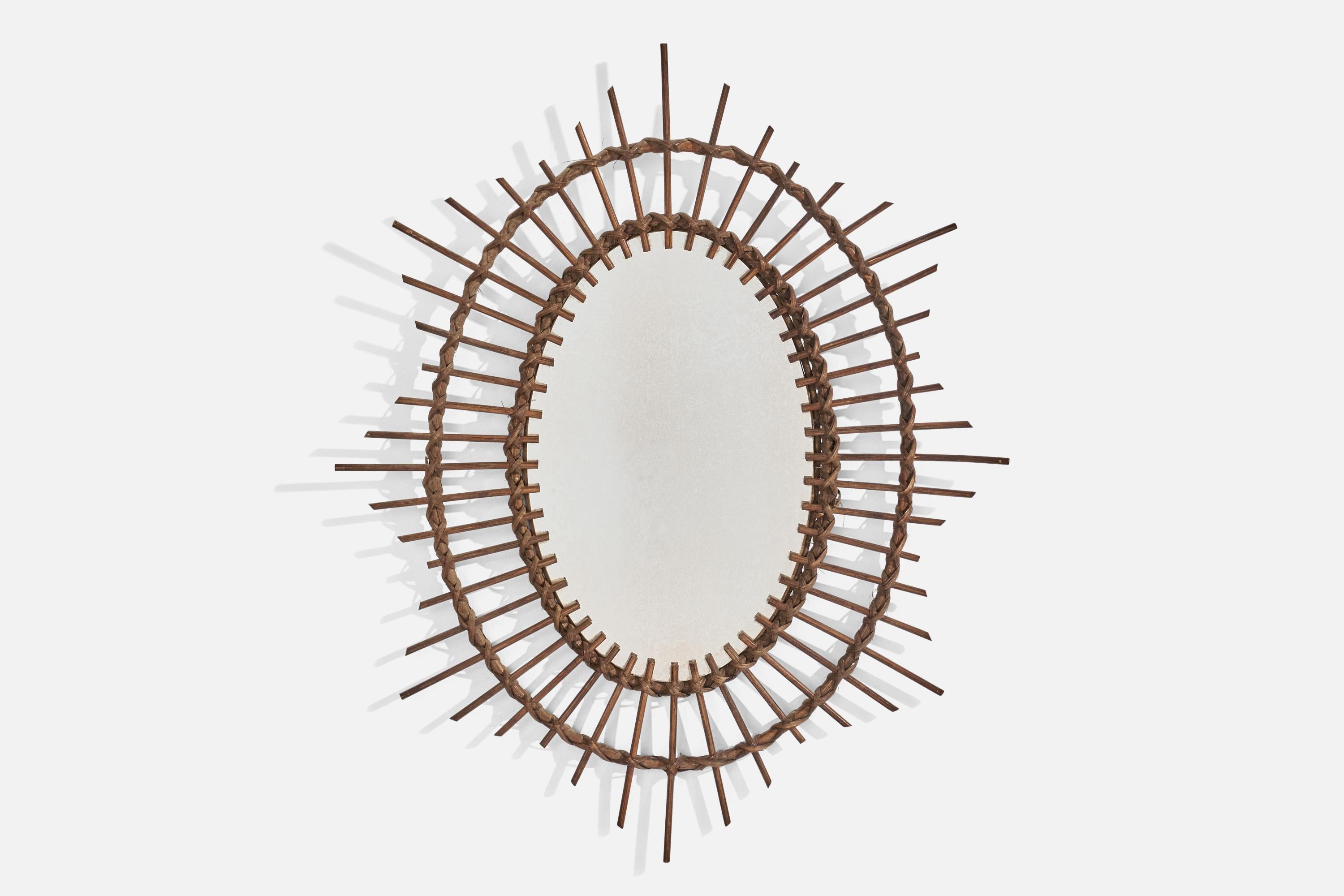 Ein ovaler Wandspiegel aus Rattan, entworfen und hergestellt von einem italienischen Designer, Italien, 1950er-1960er Jahre.
 