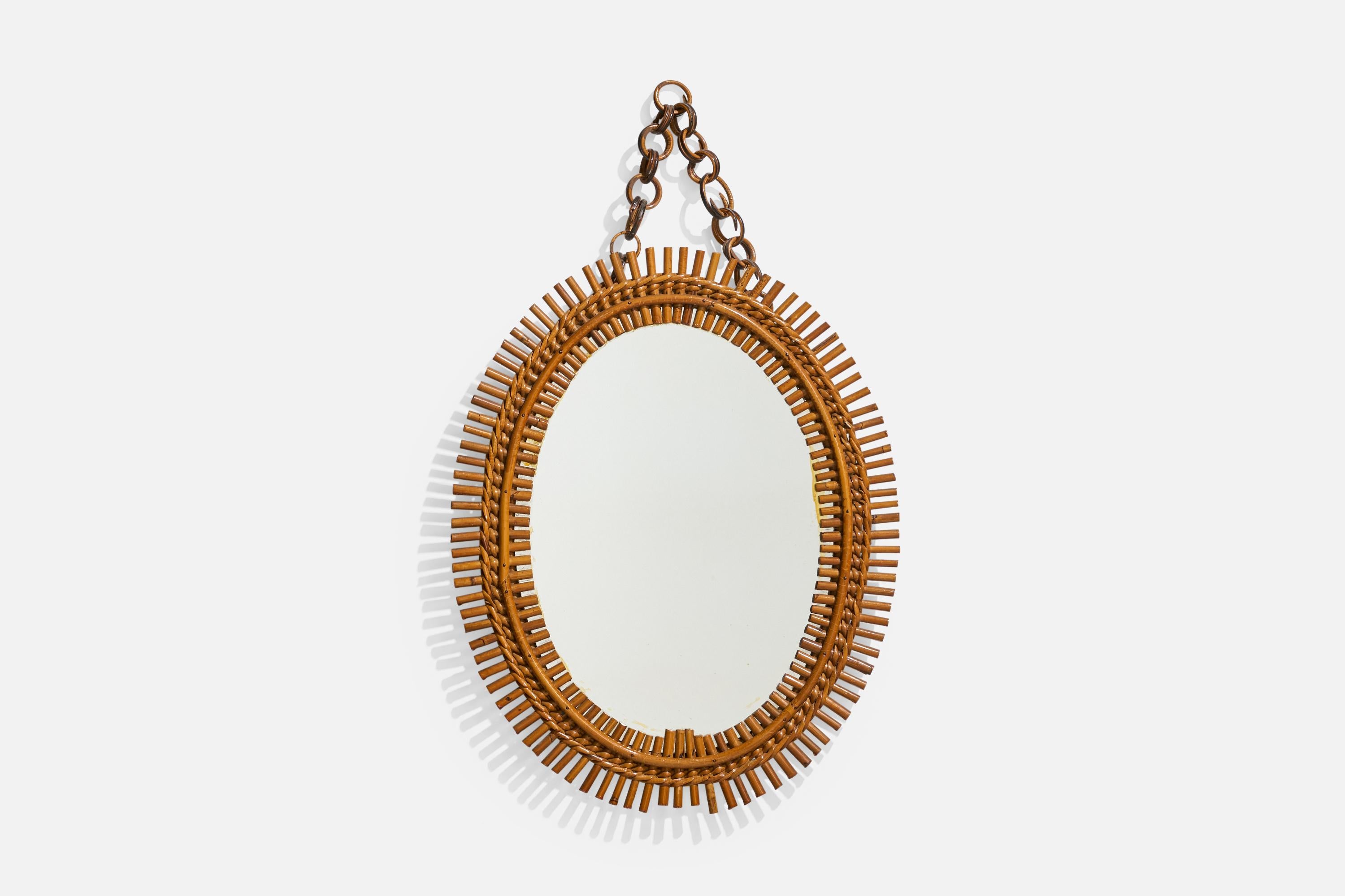 Espejo de pared ovalado, de ratán, diseñado y fabricado por un diseñador italiano, Italia, años 50-60.
 