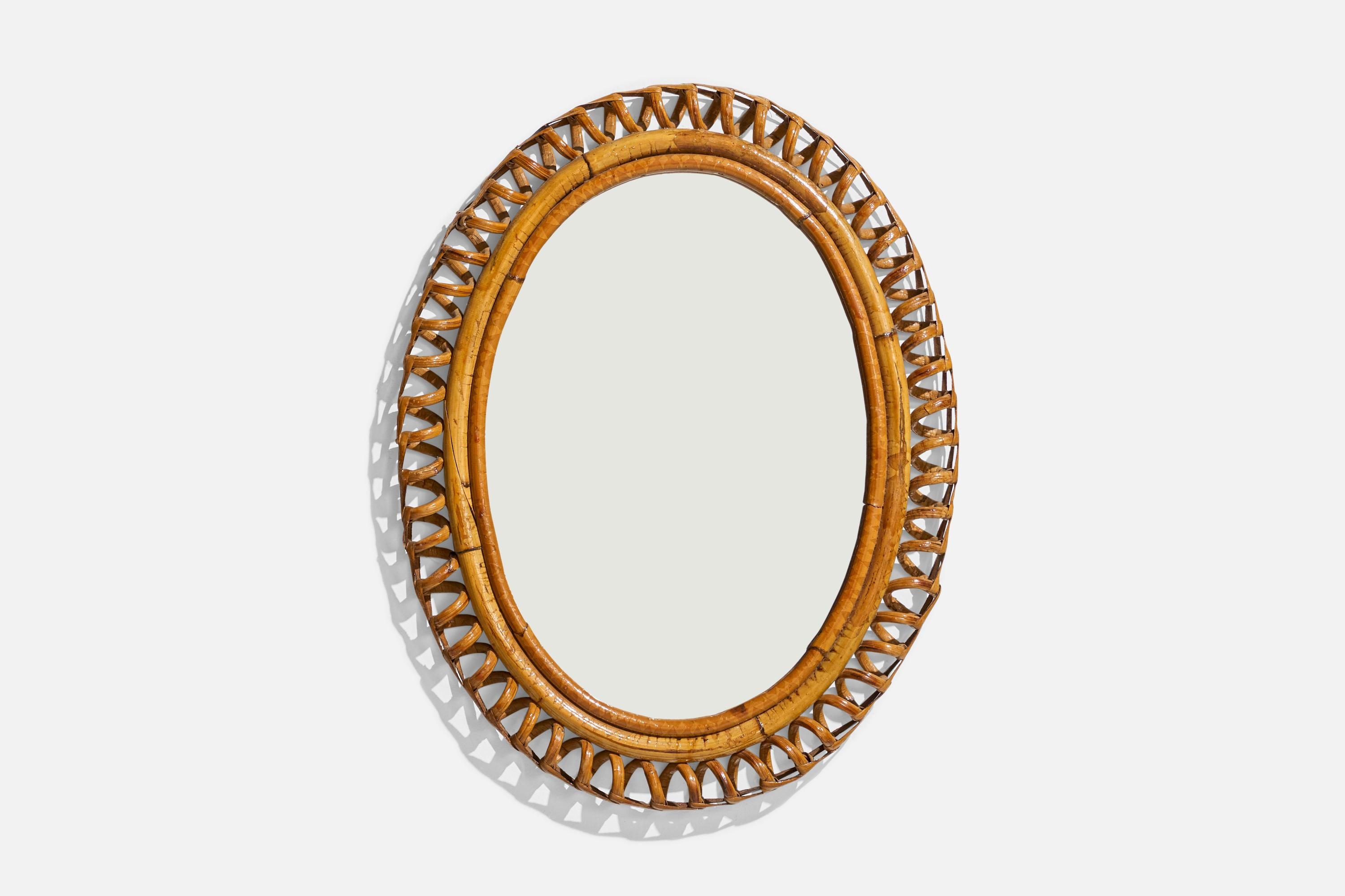 Specchio da parete ovale in rattan disegnato e prodotto da un designer italiano, Italia, anni 1950-1960.
 