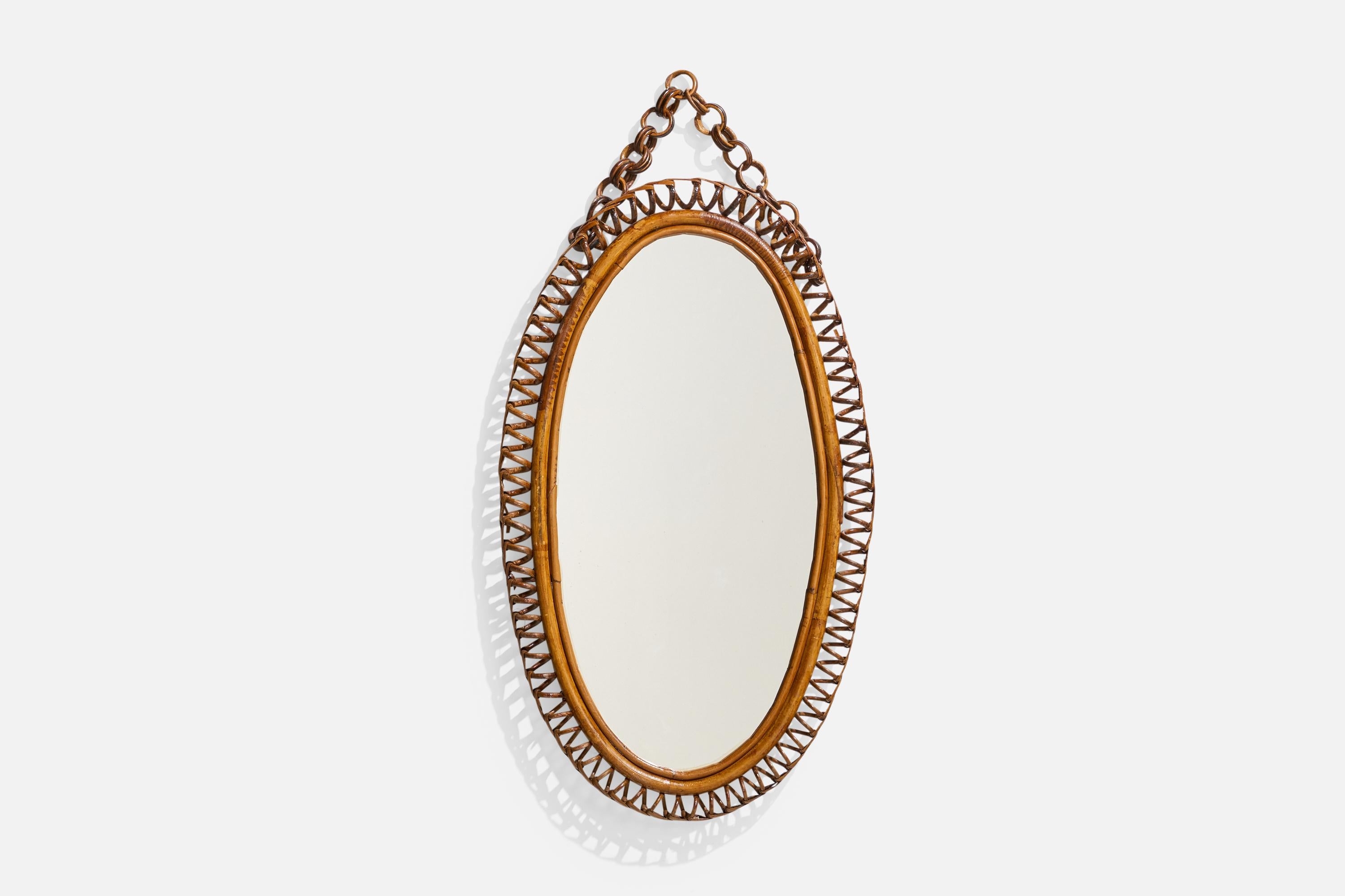 Specchio da parete ovale in rattan disegnato e prodotto da un designer italiano, Italia, anni 1950-1960.
 