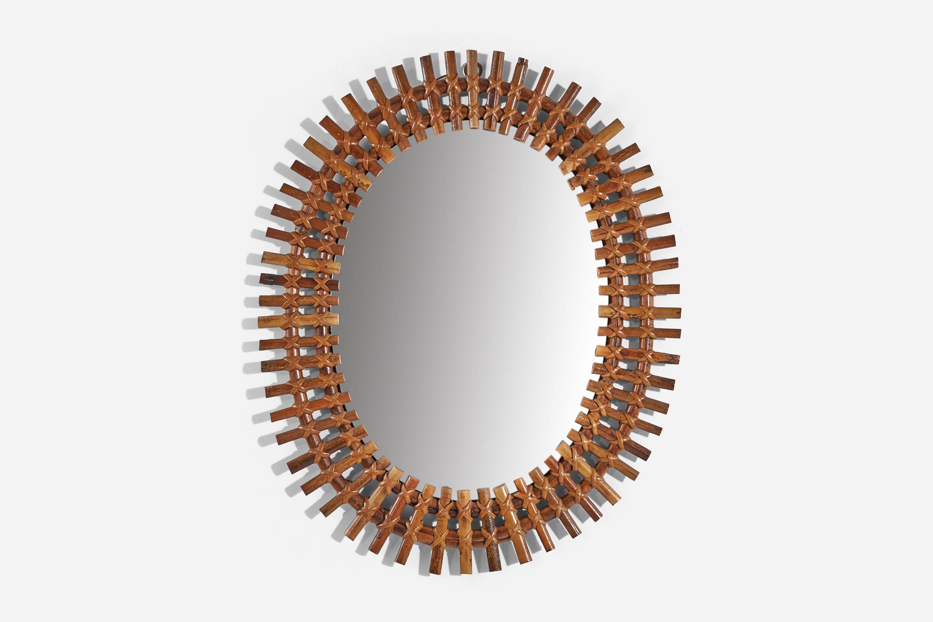 An oval, rattan wall mirror designed and produced by an Italian designer, Italy, 1950s-1960s.
 
