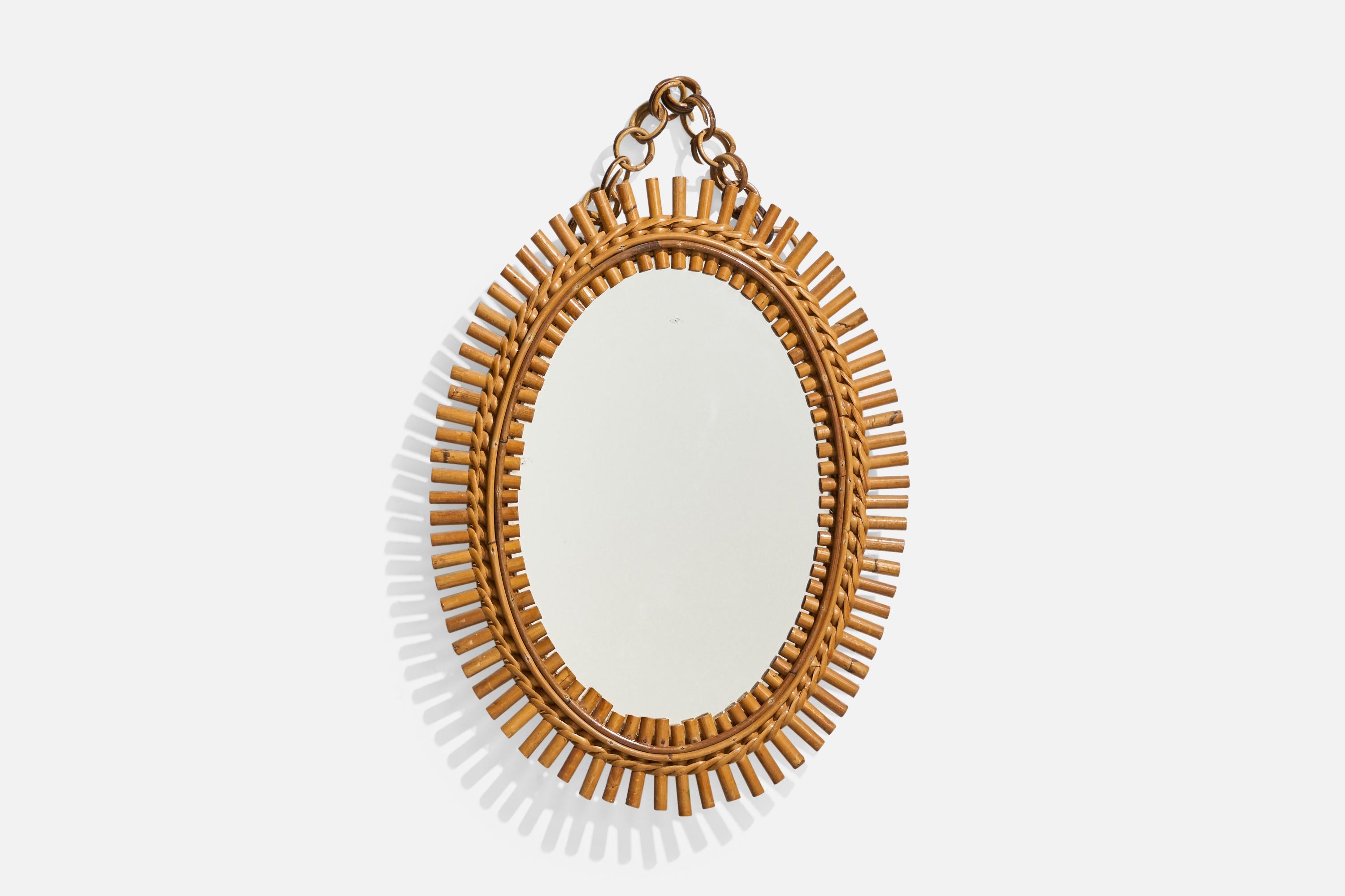 Espejo de pared ovalado, de ratán, diseñado y fabricado por un diseñador italiano, Italia, años 50-60.
 
