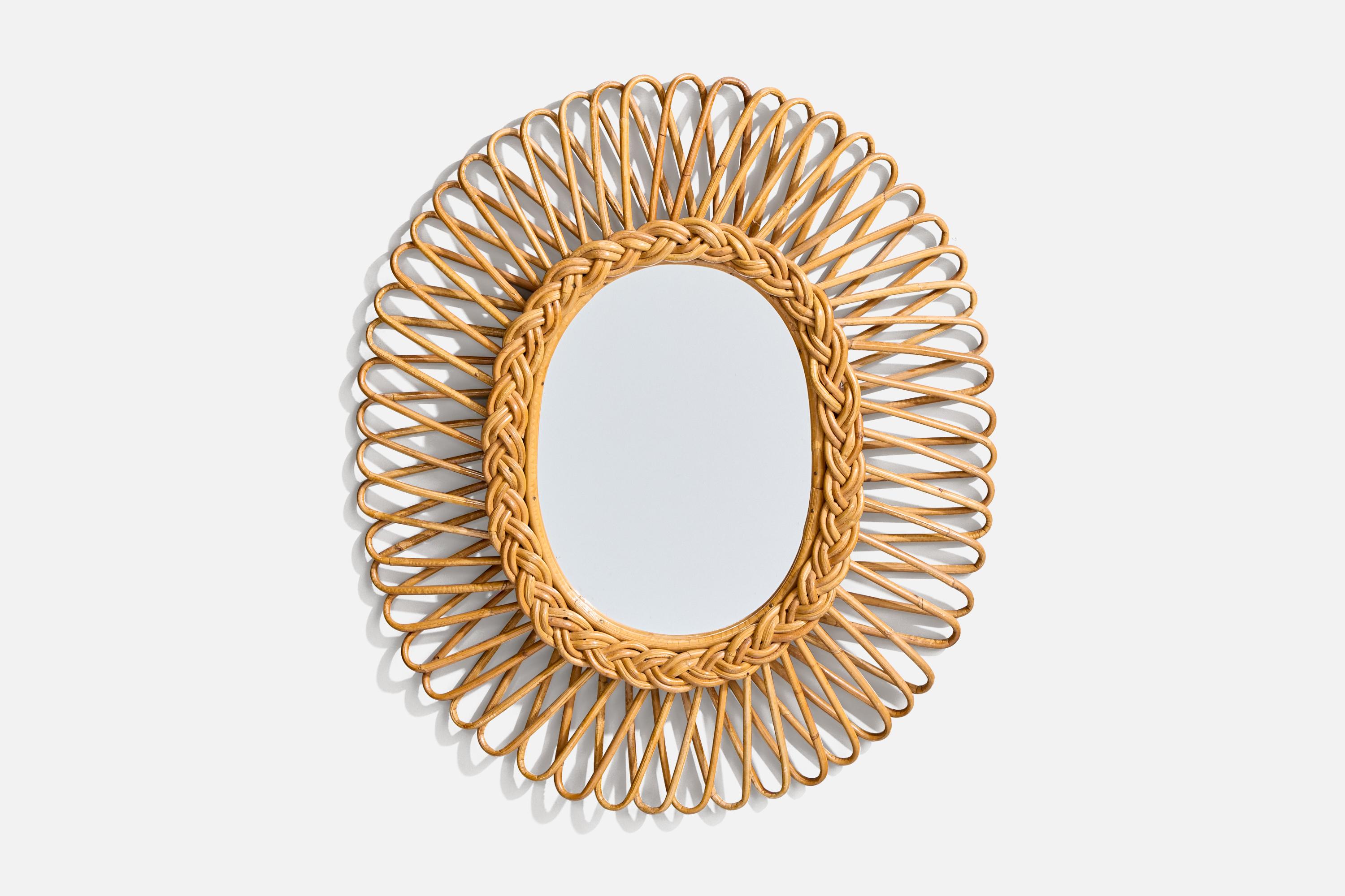 Espejo de pared ovalado, de ratán, diseñado y fabricado por un diseñador italiano, Italia, años 50-60.
 
