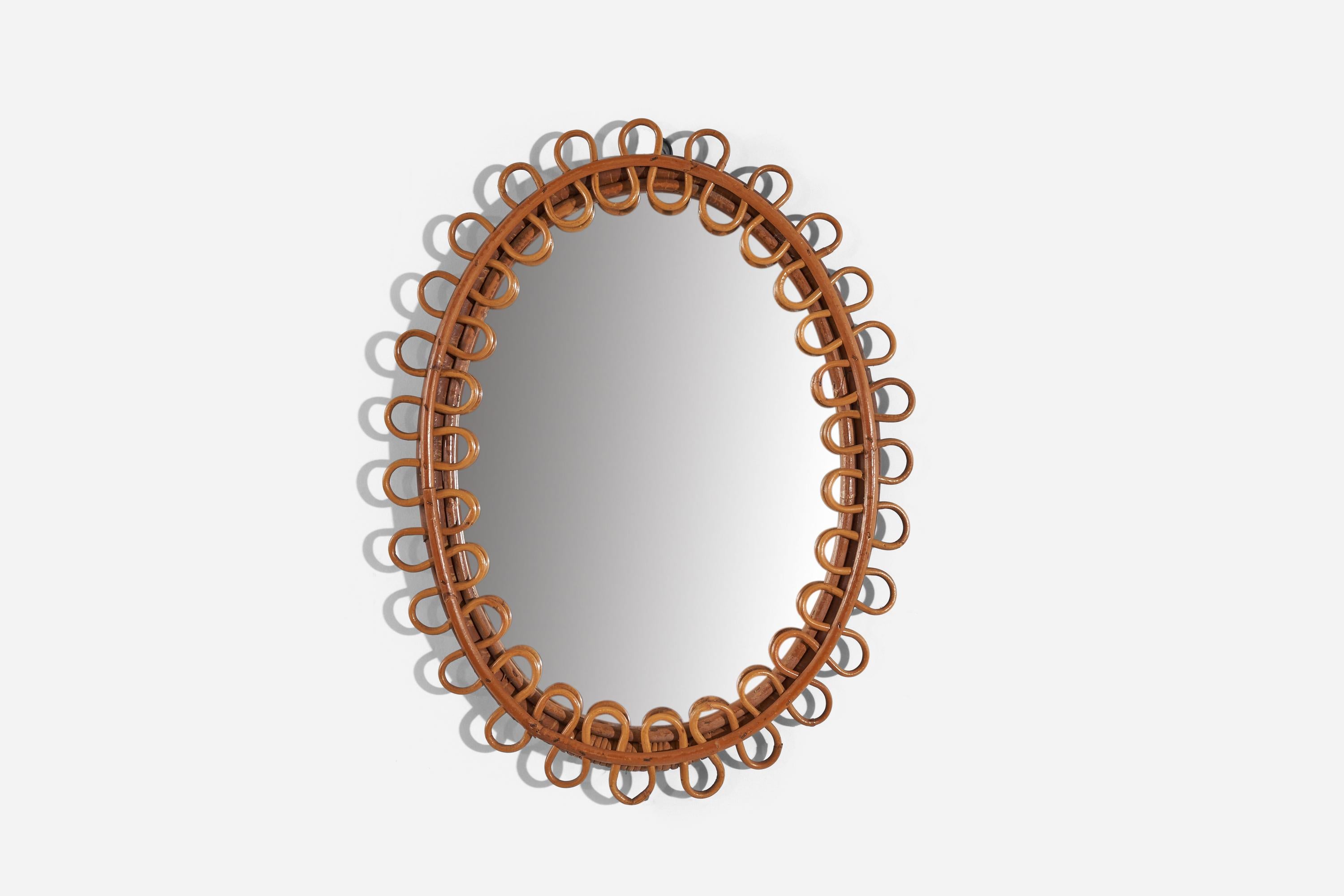 An oval rattan wall mirror designed and produced by an Italian designer, Italy, 1950s-1960s. 
 
