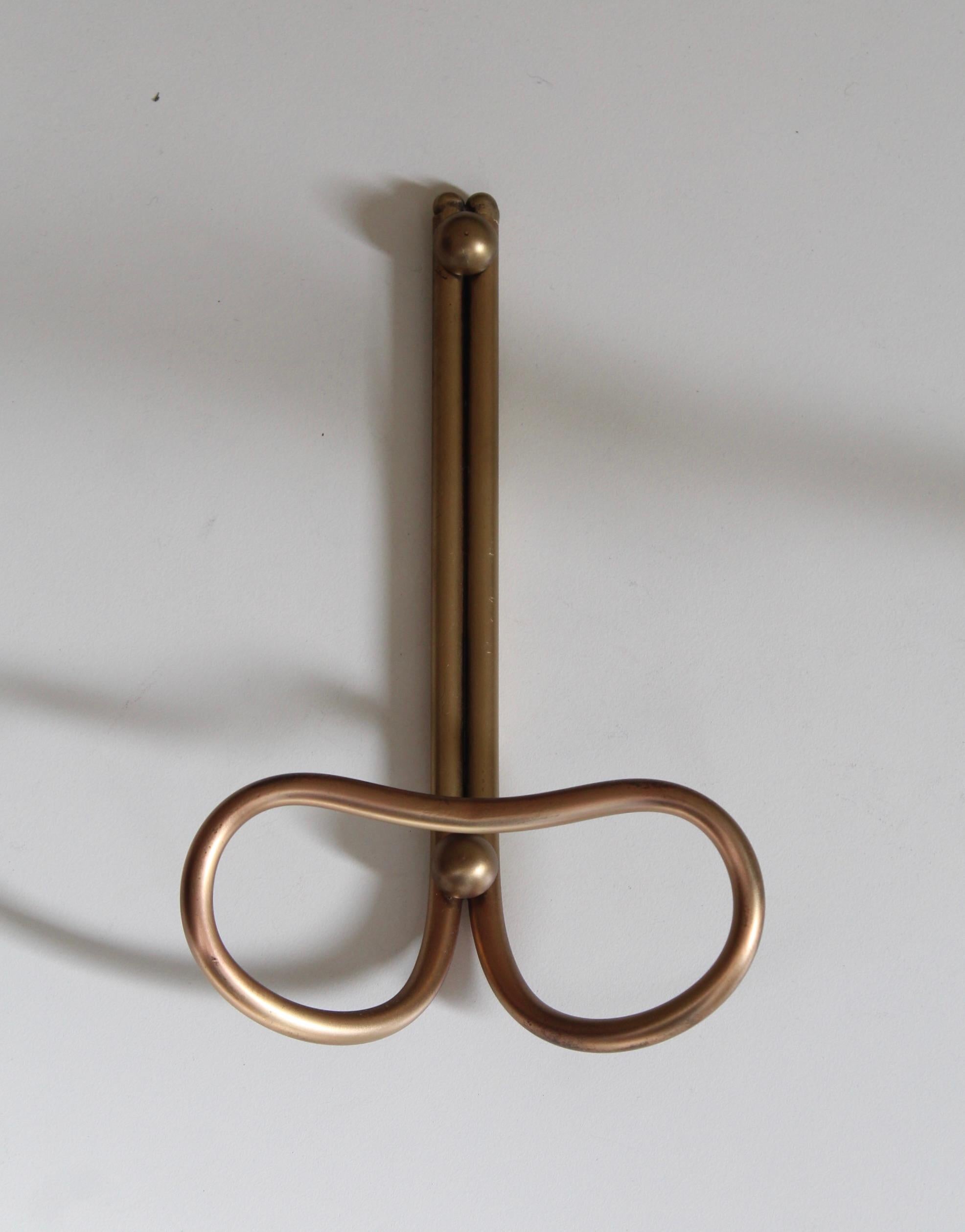 A pair of brass coat hangers, designed and produced by an Italian designer, Italy, 1940s.