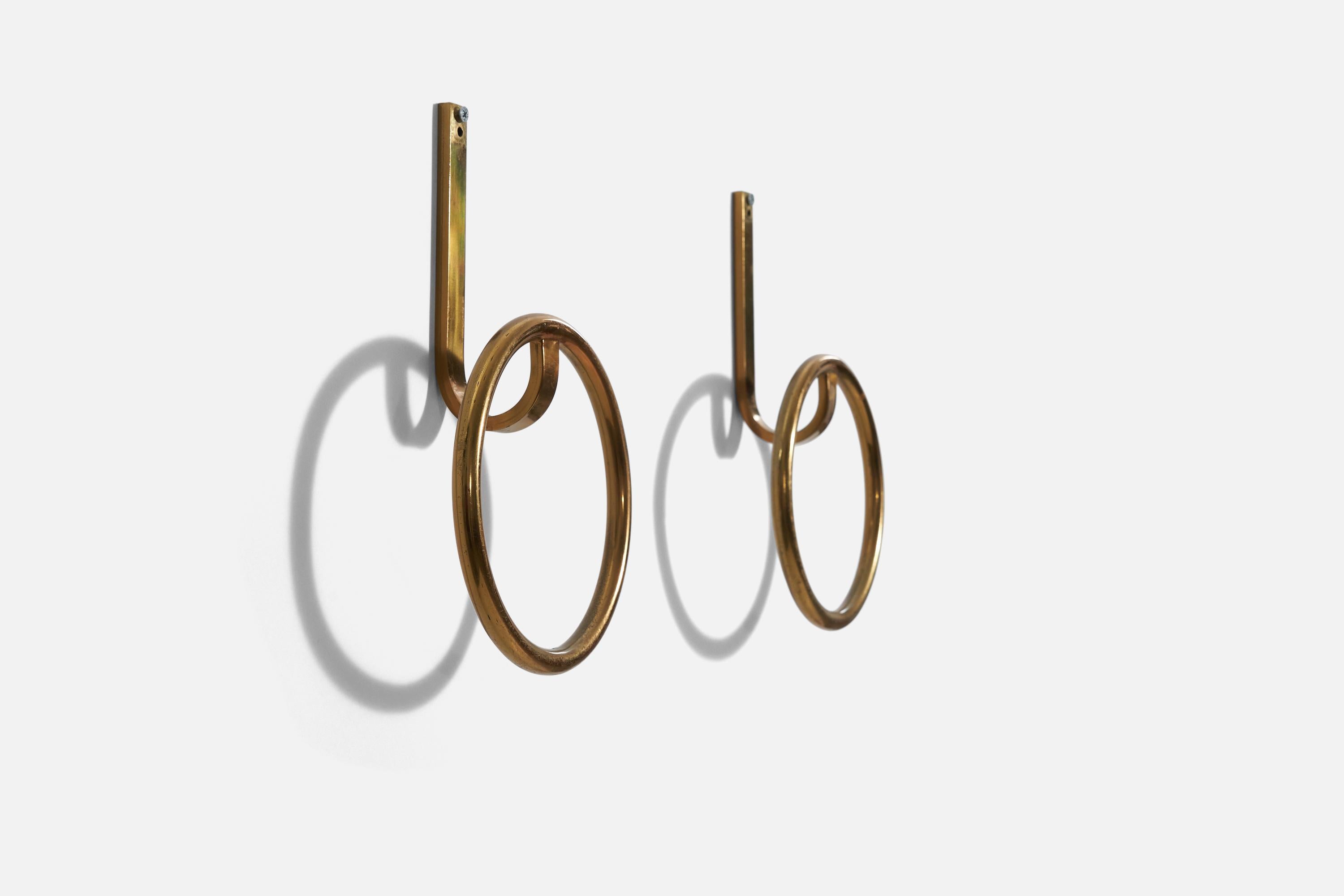 A pair of brass coat hangers, designed and produced by an Italian designer, Italy, 1950s.

