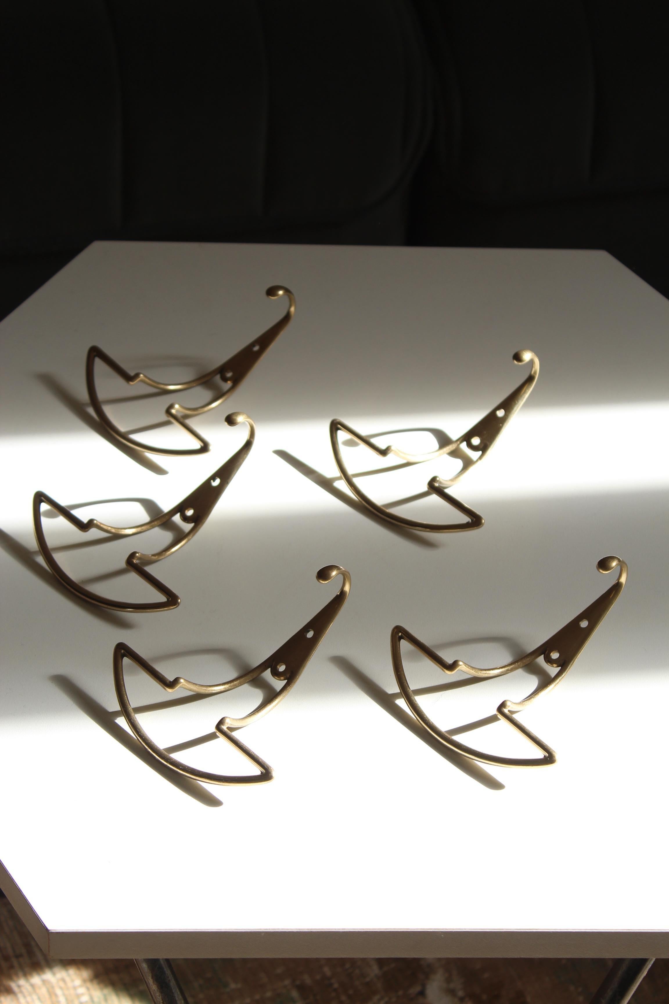 A set of 5 brass coat hangers, designed and produced by an Italian designer, Italy, 1940s.
