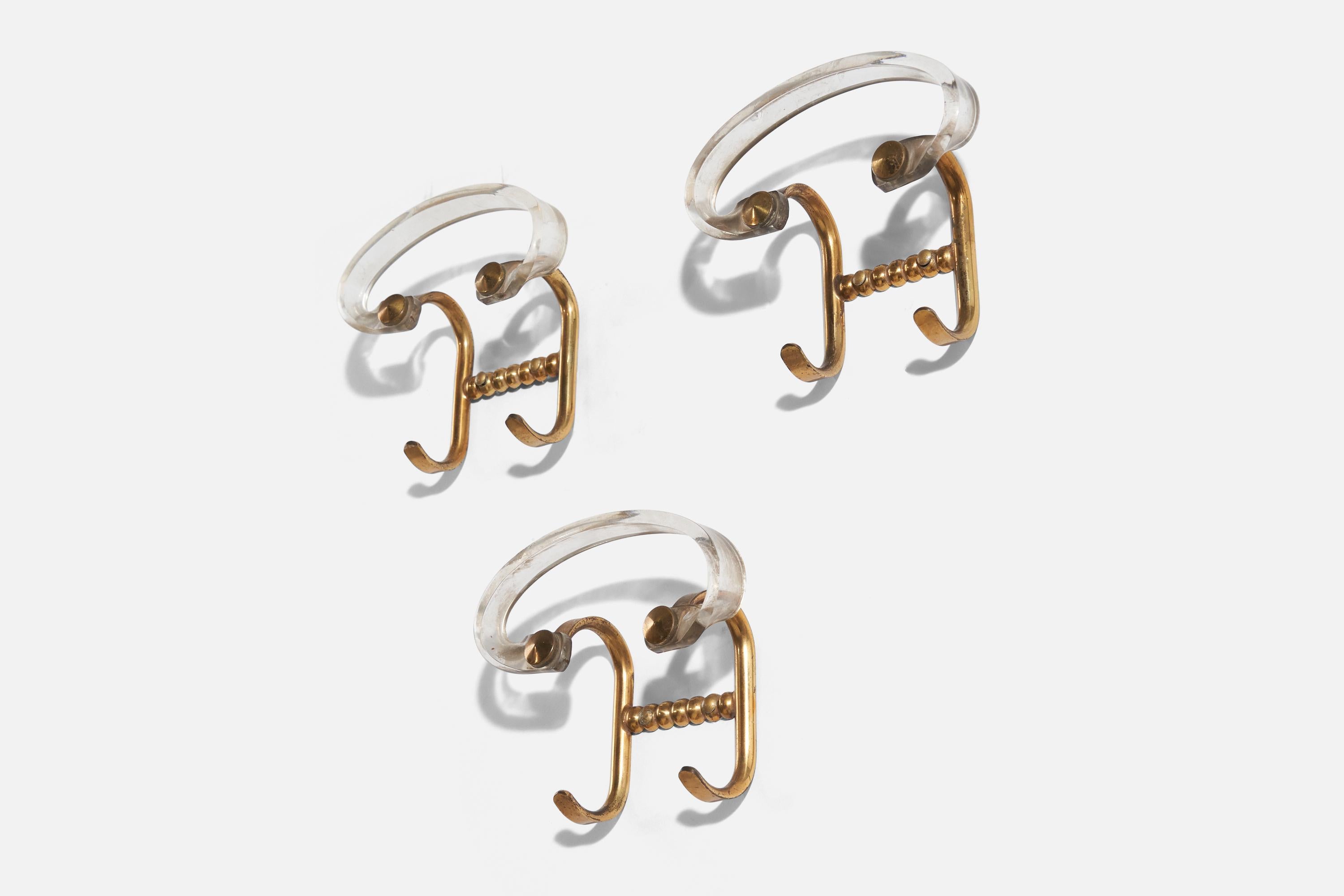 A set of three brass and acrylic coat hangers, designed and produced by an Italian designer, Italy, 1940s.