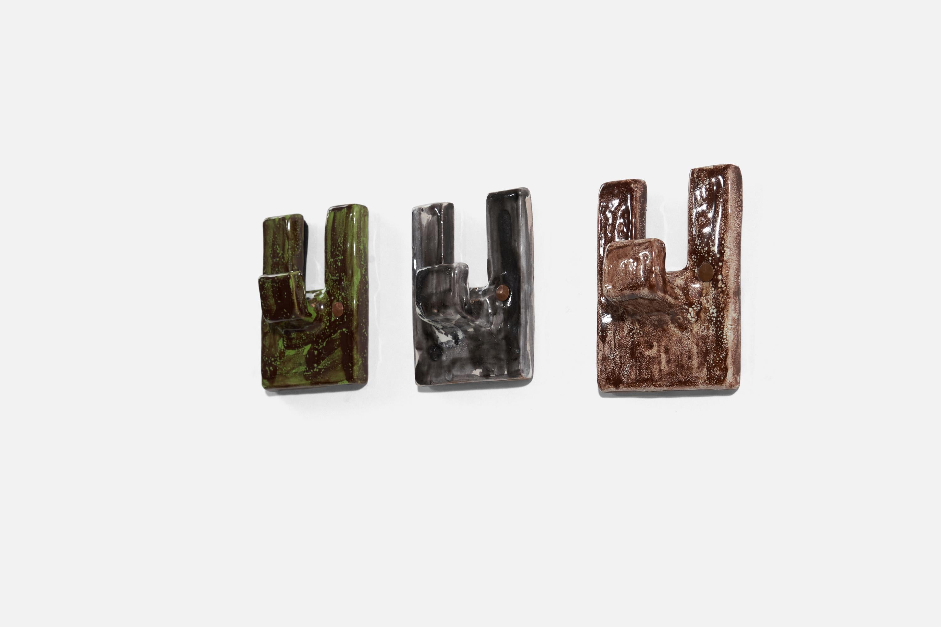 A set of three ceramic coat hangers, designed and produced by an Italian designer, Italy, 1950s.

Glaze features brown-grey-green colors.