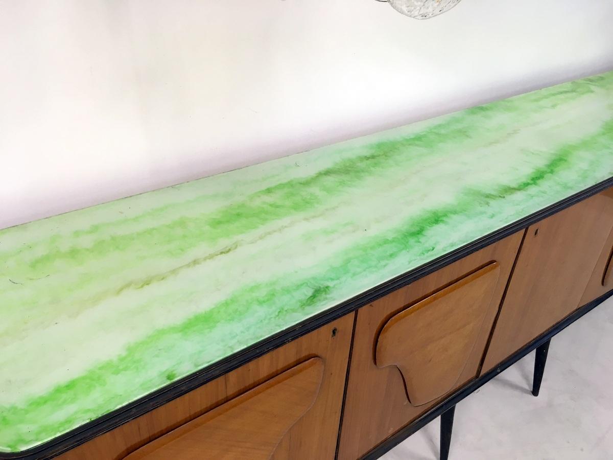 An excellent designer Italian sideboard by Mobilificio f.lli Barsotti in original unrestored condition, kick out legs with a highly decorative green marbled effect glass top, made in walnut the piece has five large cupboards giving excellent storage