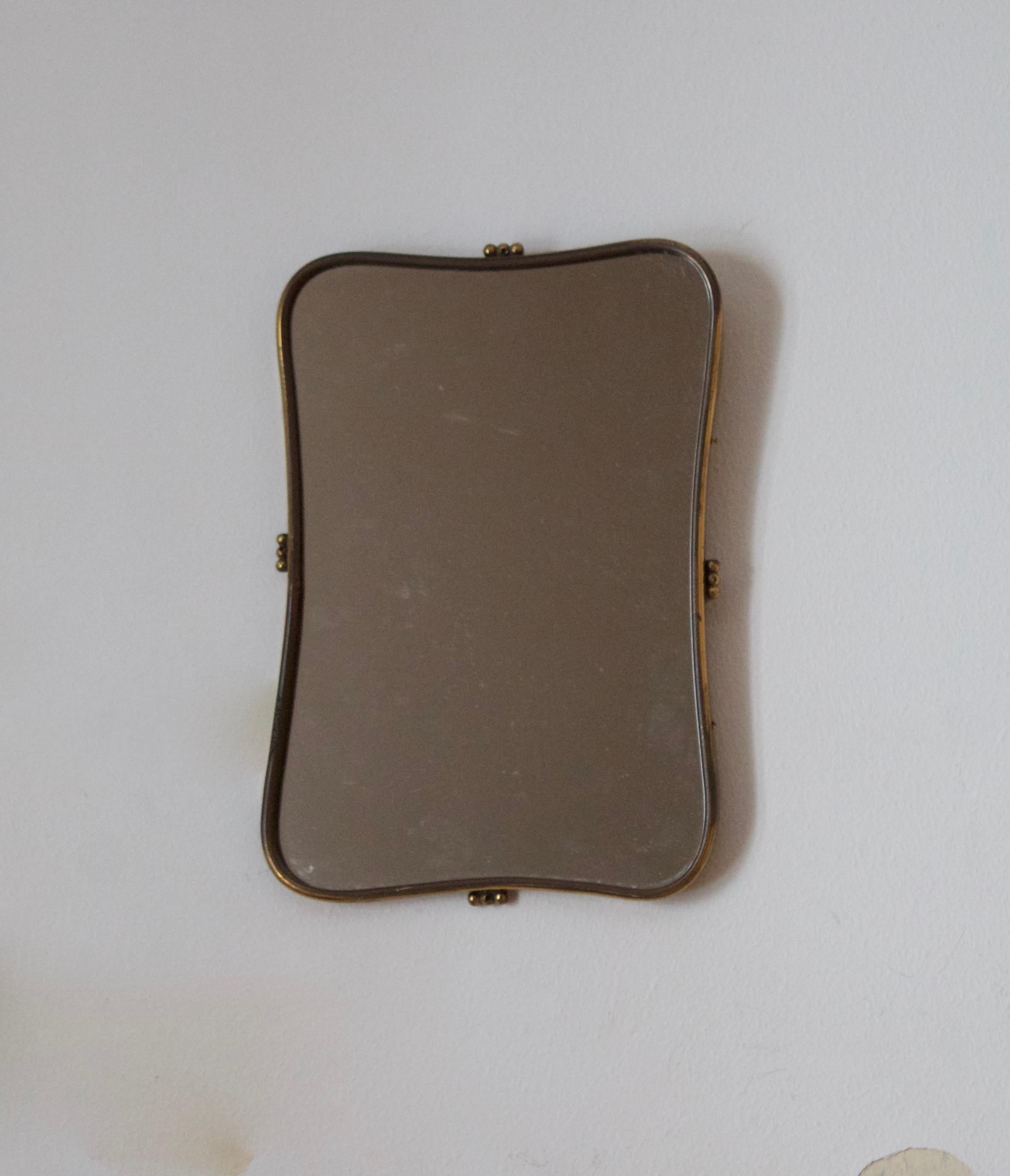 A very small wall mirror, produced in Italy, 1950s. Cut mirror glass is framed in brass frame. Features simple ornamentation.

Other designers of the period include Gio Ponti, Fontana Arte, Paolo Buffa, Franco Albini, and Jean Royere.
