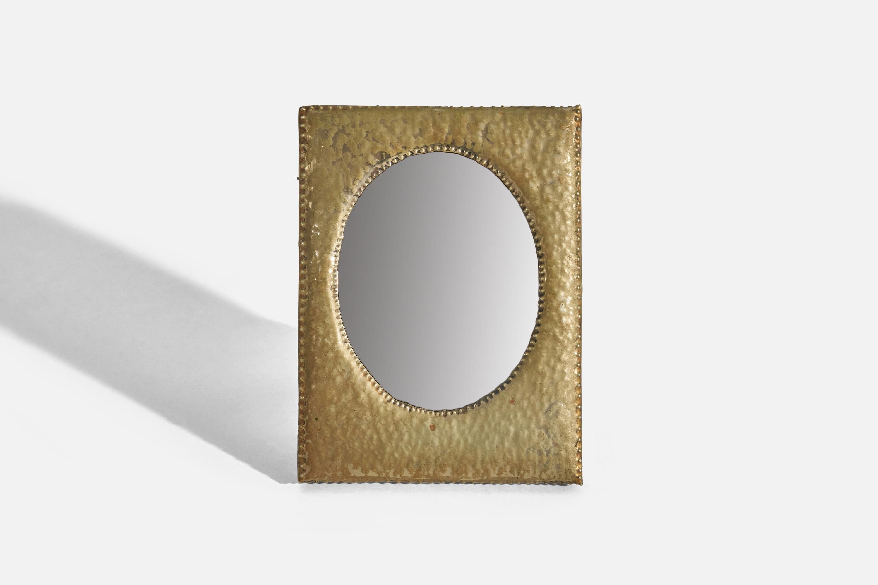 A small hammered brass table or wall mirror, designed and produced in Italy, 1930s. 

