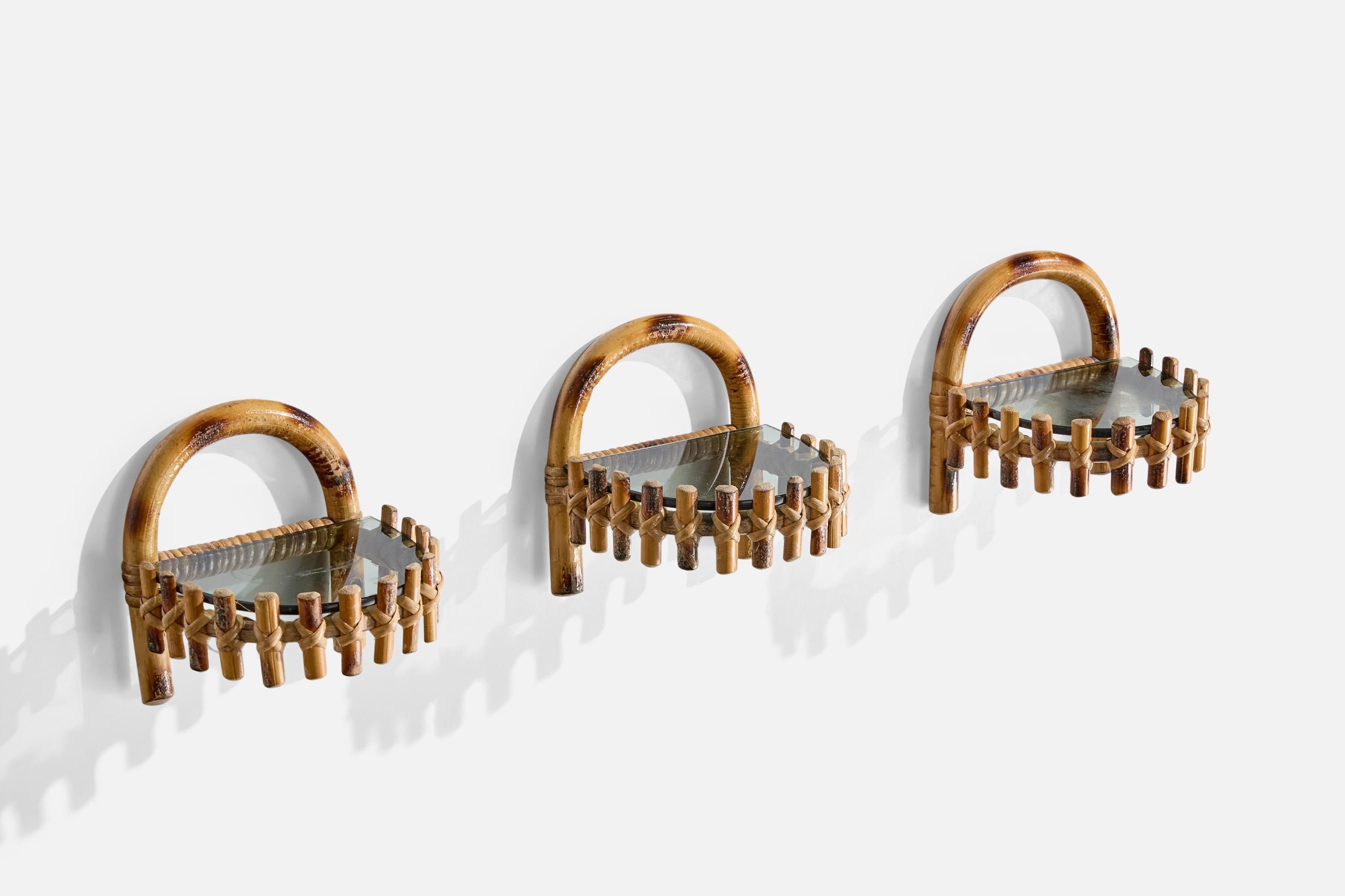 A set of three small bamboo, rattan and smoked glass wall shelves designed and produced in Italy, c. 1960s.

Dimensions: 6” H x 6” W x 6” D