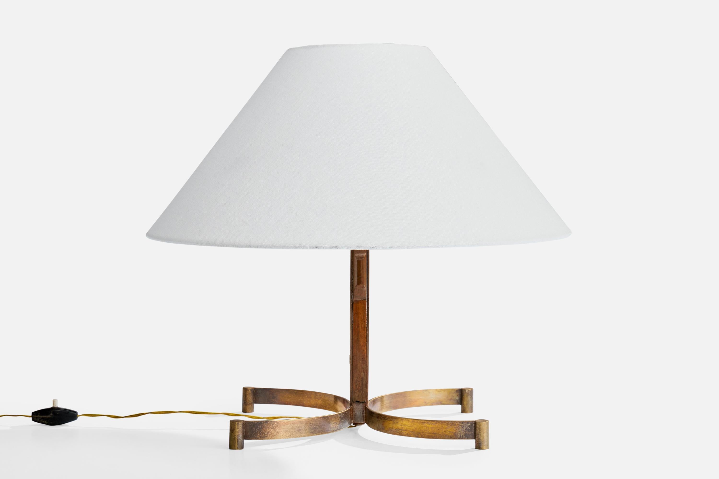 A brass, teak and white fabric table lamp designed and produced in Italy, c. 1950s.

Oxidation present to brass. 

Later paired lampshade, mounting present for unknown original configuration.

Wear to wood consistent with age and use

Dimensions of
