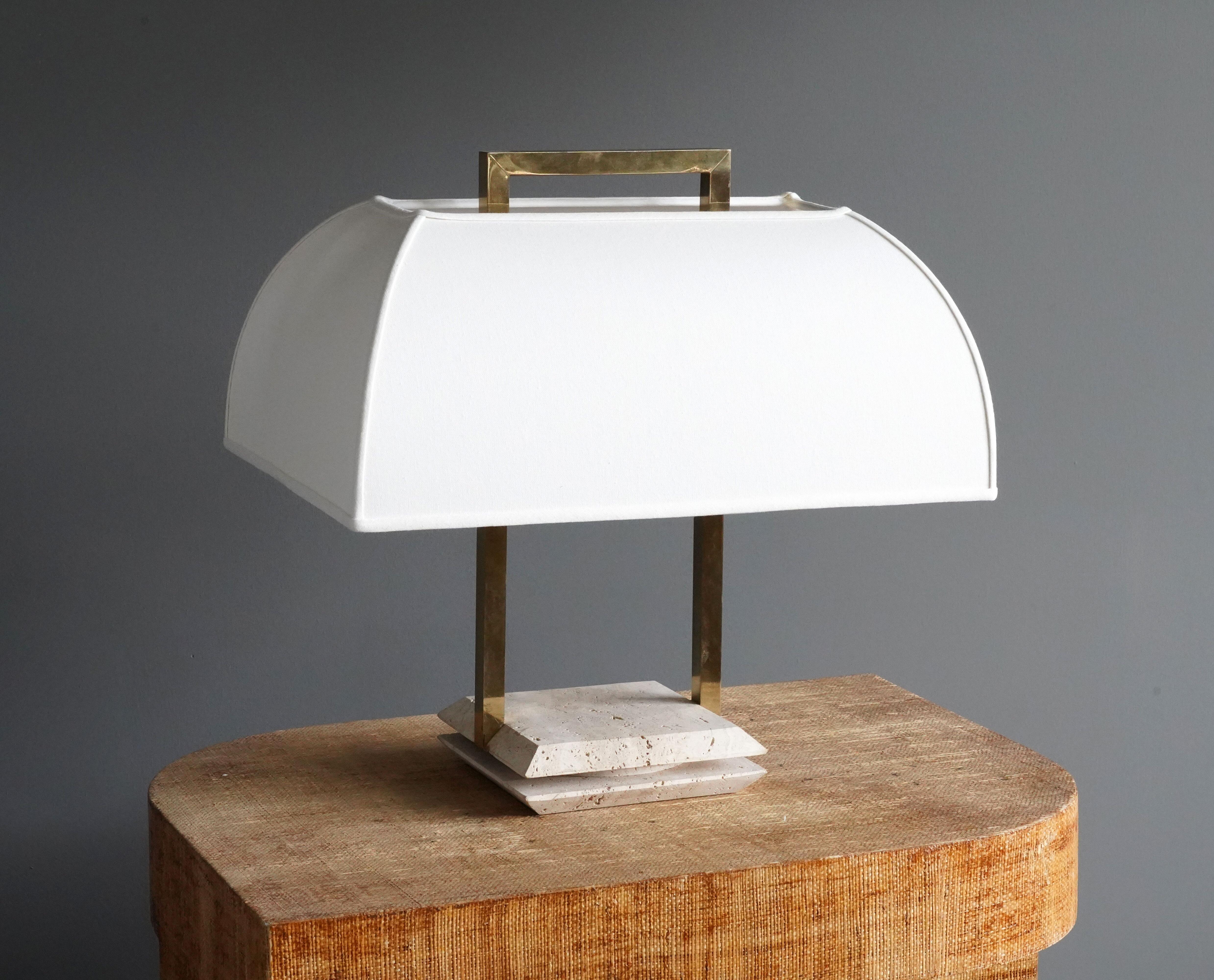 A table lamp designed and produced in Italy, 1970s. Features brass and a travertine base Lampshade recovered in white fabric. 

Other designers of the period include Max Ingrand, Angelo Lelii, Paul Evans, Gabriella Crespi, and Paavo Tynell.