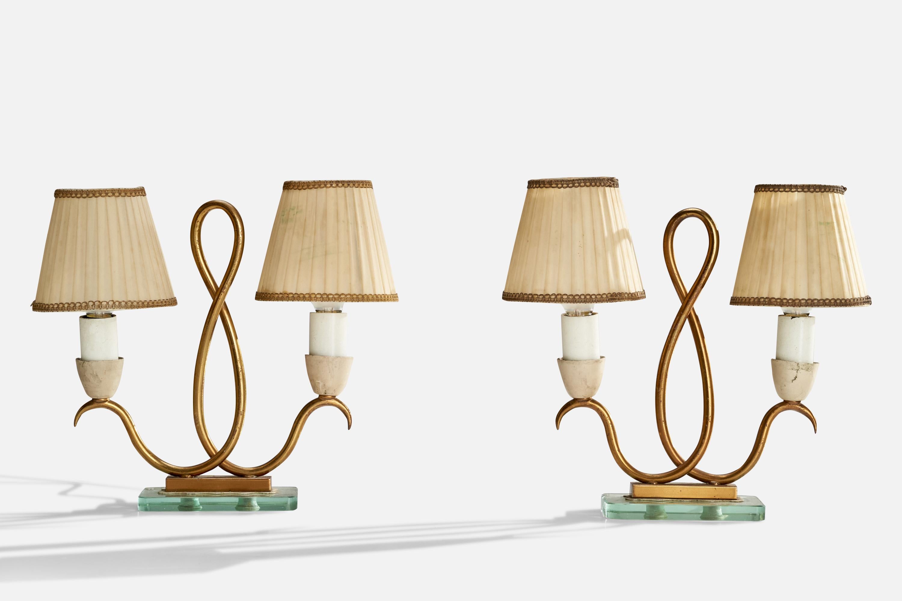 A pair of brass, green glass and beige fabric table lamps designed and produced in Italy, c. 1940s.

Dimensions of Lamp with Shade (inches): 10” H x 10.5” Diameter
Bulb Specifications: E-14 Bulbs
Number of Sockets (per fixture): 2
Sold with