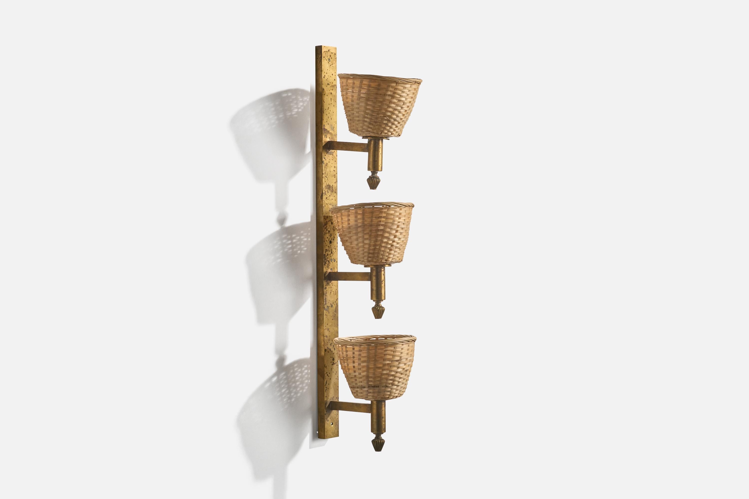 A brass and rattan wall light designed and produced in Italy, 1930s. 

Heavy oxidation present throughout brass fixture. Replaced lampshades.

Overall Dimensions (inches): 33.5” H x 7” W x 9.25” D

Dimensions of back plate (inches) : 33.5” H x 2” W