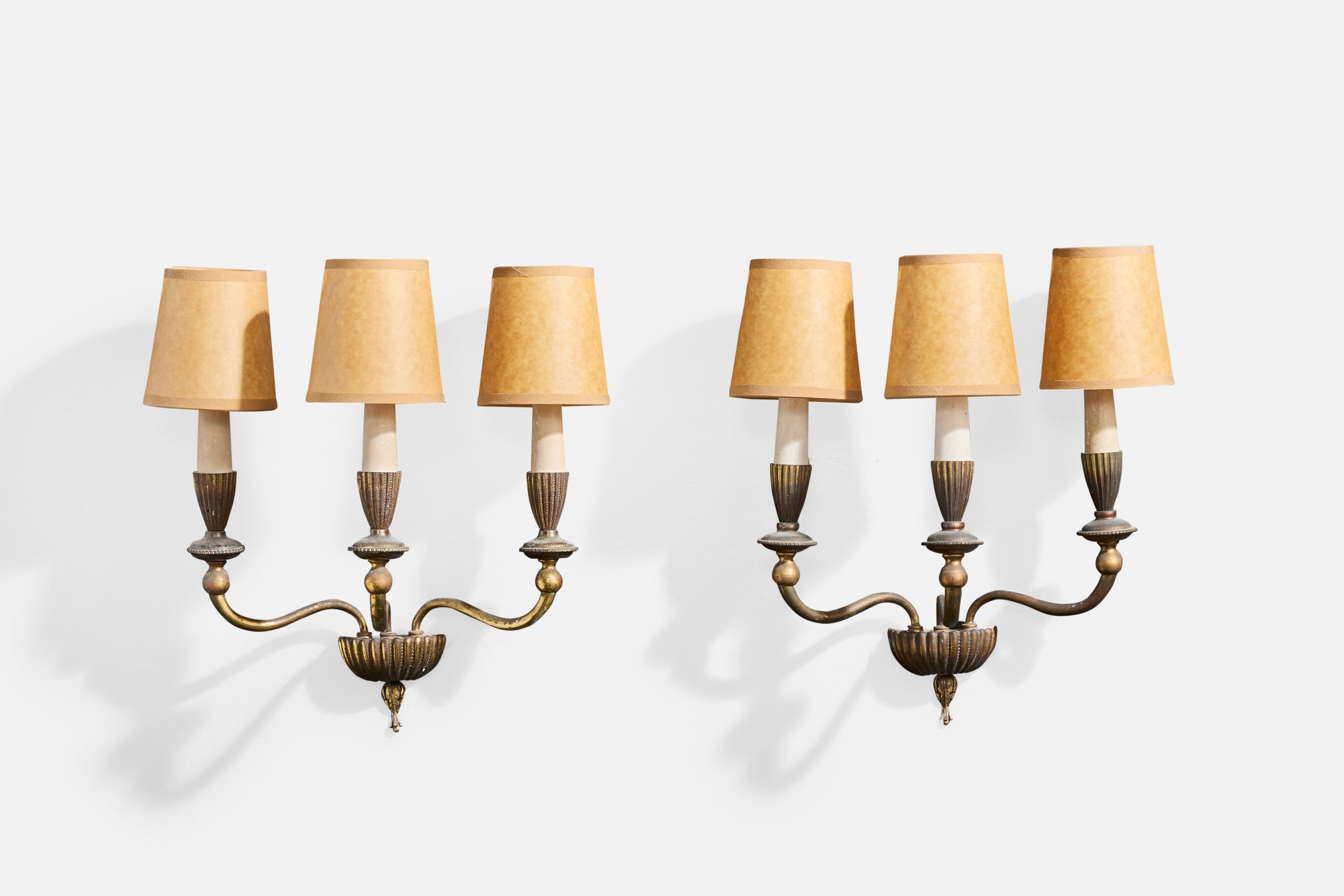 A pair of brass, off-white bakelite and brown parchment paper wall lights designed and produced in Italy, c. 1930s.

Brass presents with heavy oxidation throughout. 

Overall Dimensions (Inches): 15.5