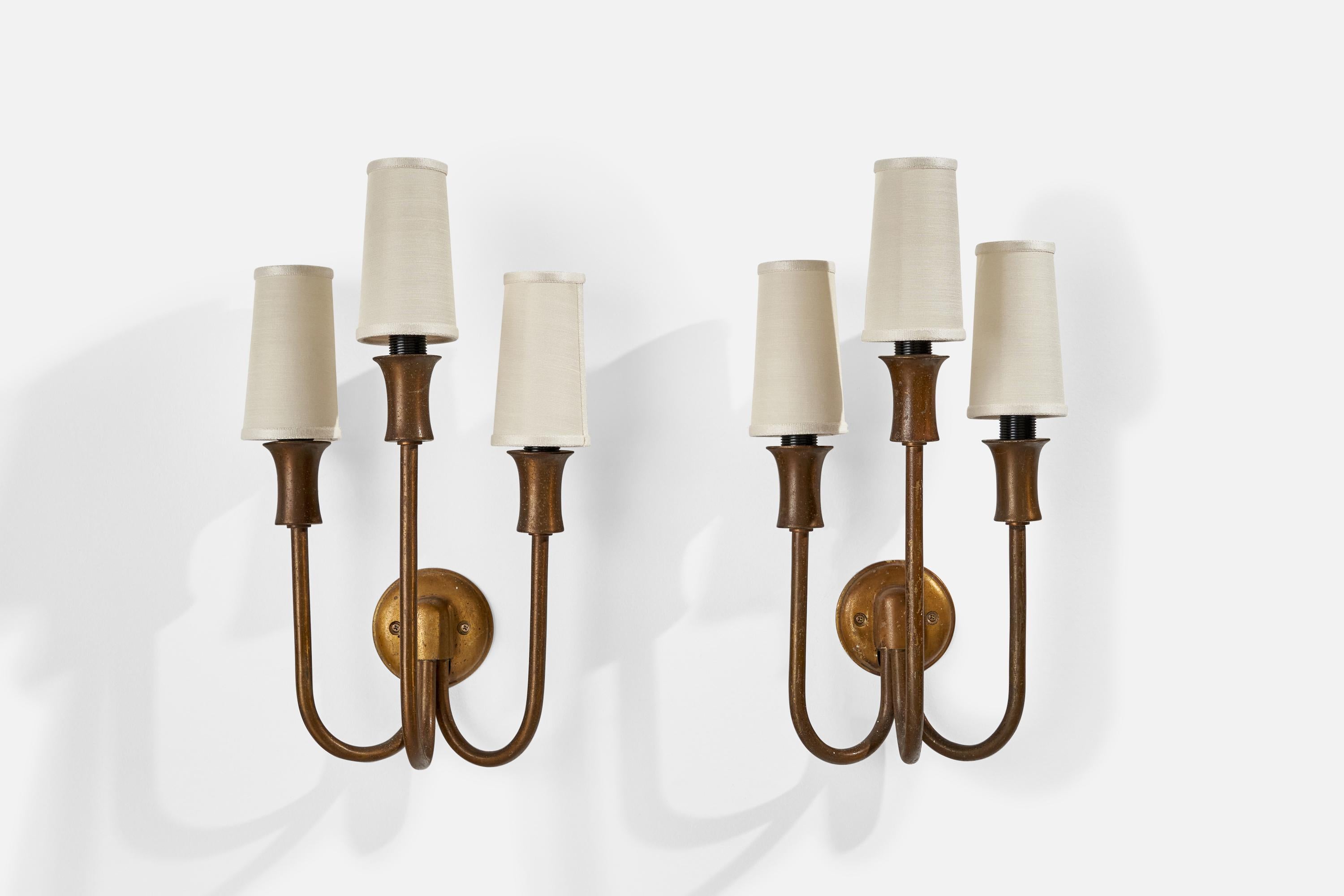 A pair of three-armed brass and white fabric wall lights designed and produced in Italy, c. 1940s.

Overall Dimensions (inches): 17.5” H x 8.25” W x 8..5” D
Back Plate Dimensions (inches): 3.58” H x 0.50” D
Bulb Specifications: E-12 Bulb
Number of