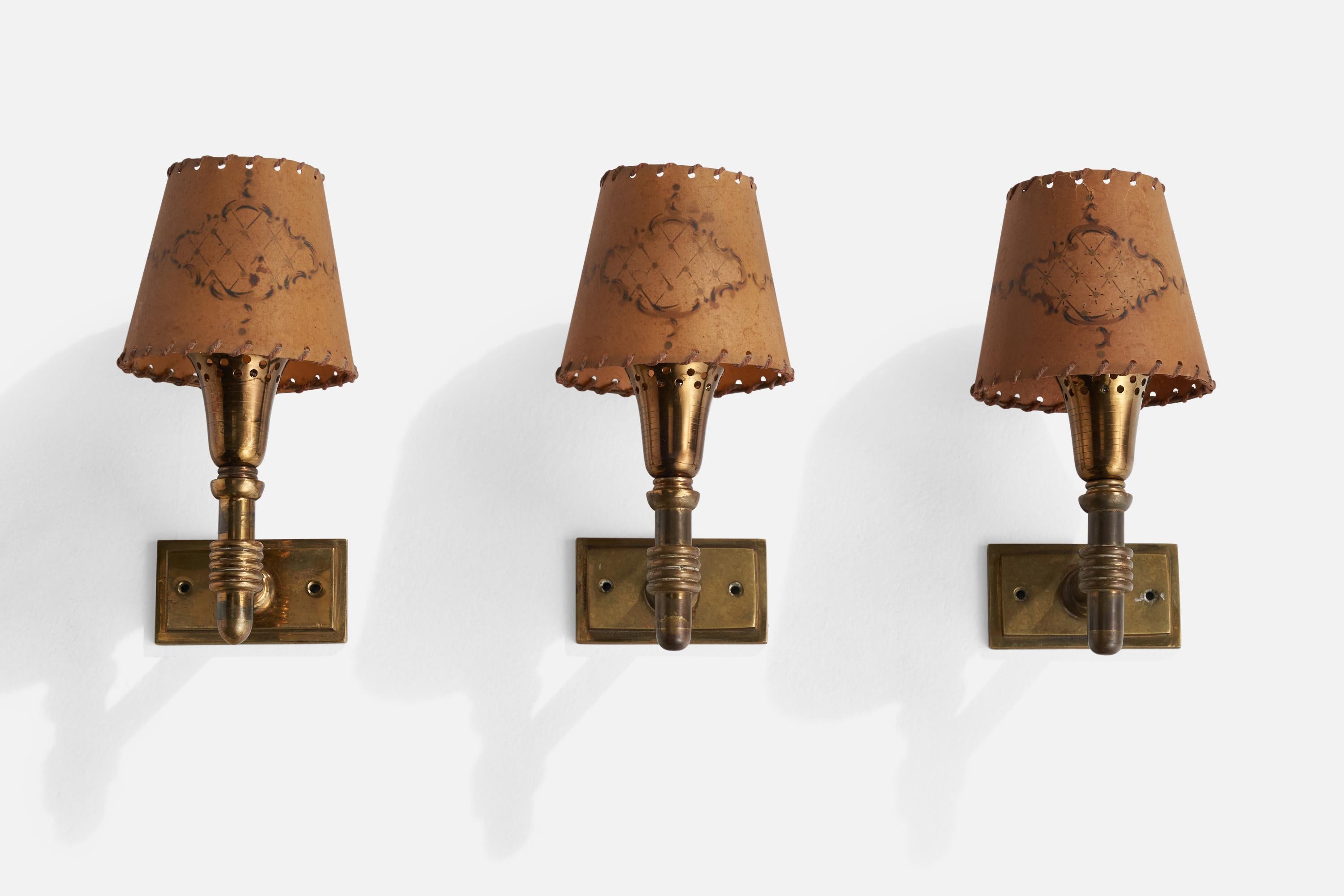 A set of 3 brass and beige parchment paper wall lights designed and produced in Italy, 1930s.

Overall Dimensions (inches): 4.75” H x 3.5” W x 5” D
Back Plate Dimensions (inches): 1.75” H x 3.5” W x .5” D
Bulb Specifications: E-14 Bulb
Number of