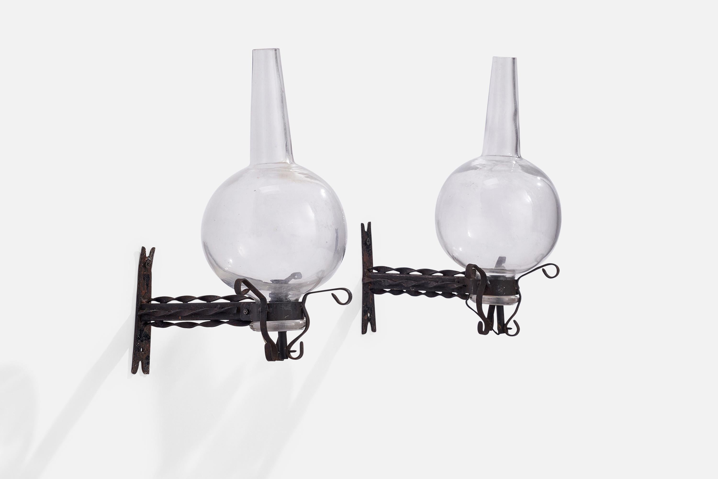 A pair of wrought iron and glass wall lights designed and produced in Italy, 1930s.

Overall Dimensions (inches): 14.5” H x 6”  W x 10”  D
Back Plate Dimensions (inches): 5.5” H x 1.25” W x .25” D
Bulb Specifications: E-14 Bulb
Number of Sockets: