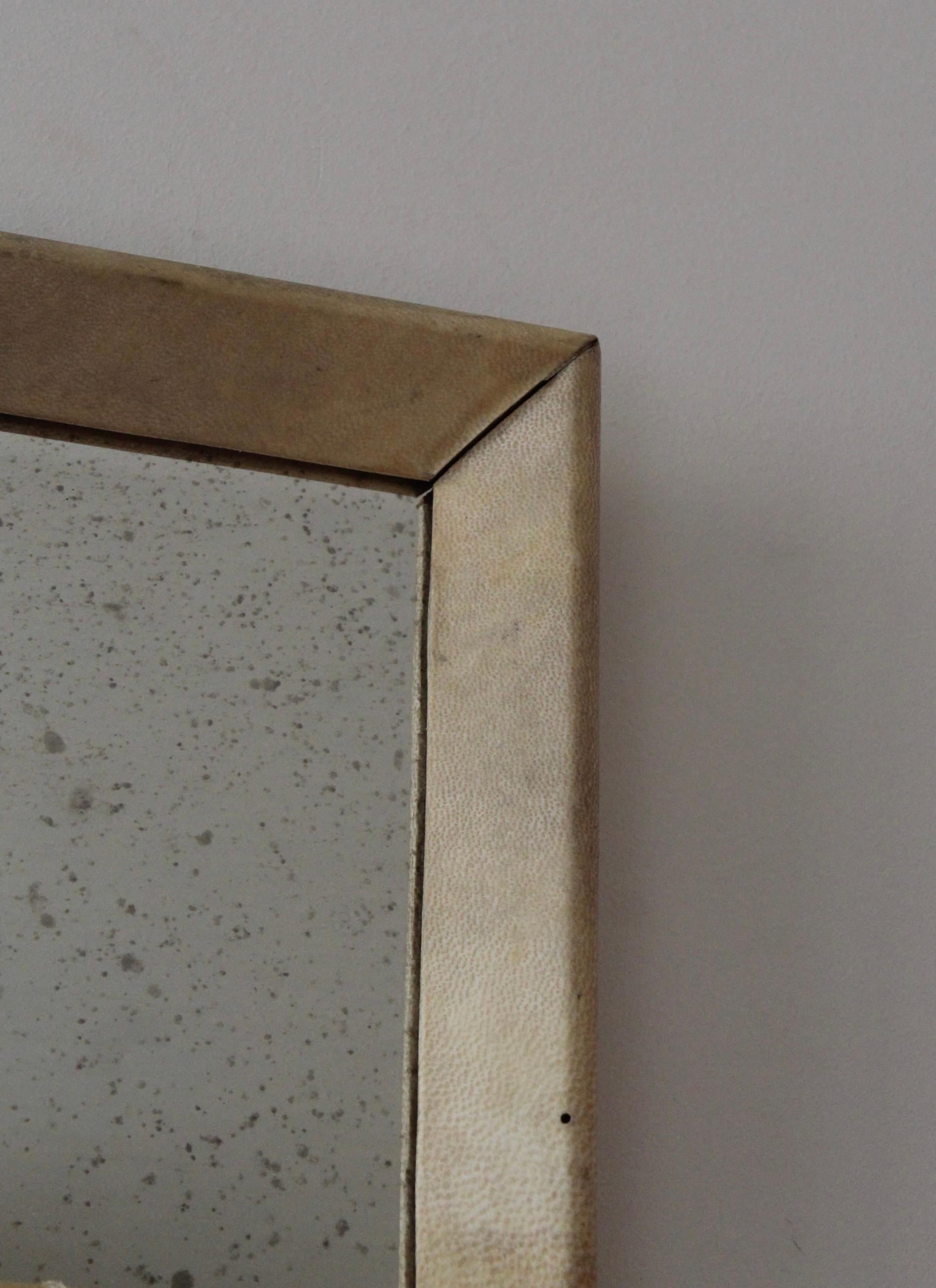 A small wall mirror, designed and produced in Italy, 1940s. Features a wooden frame covered in beige-painted leather.