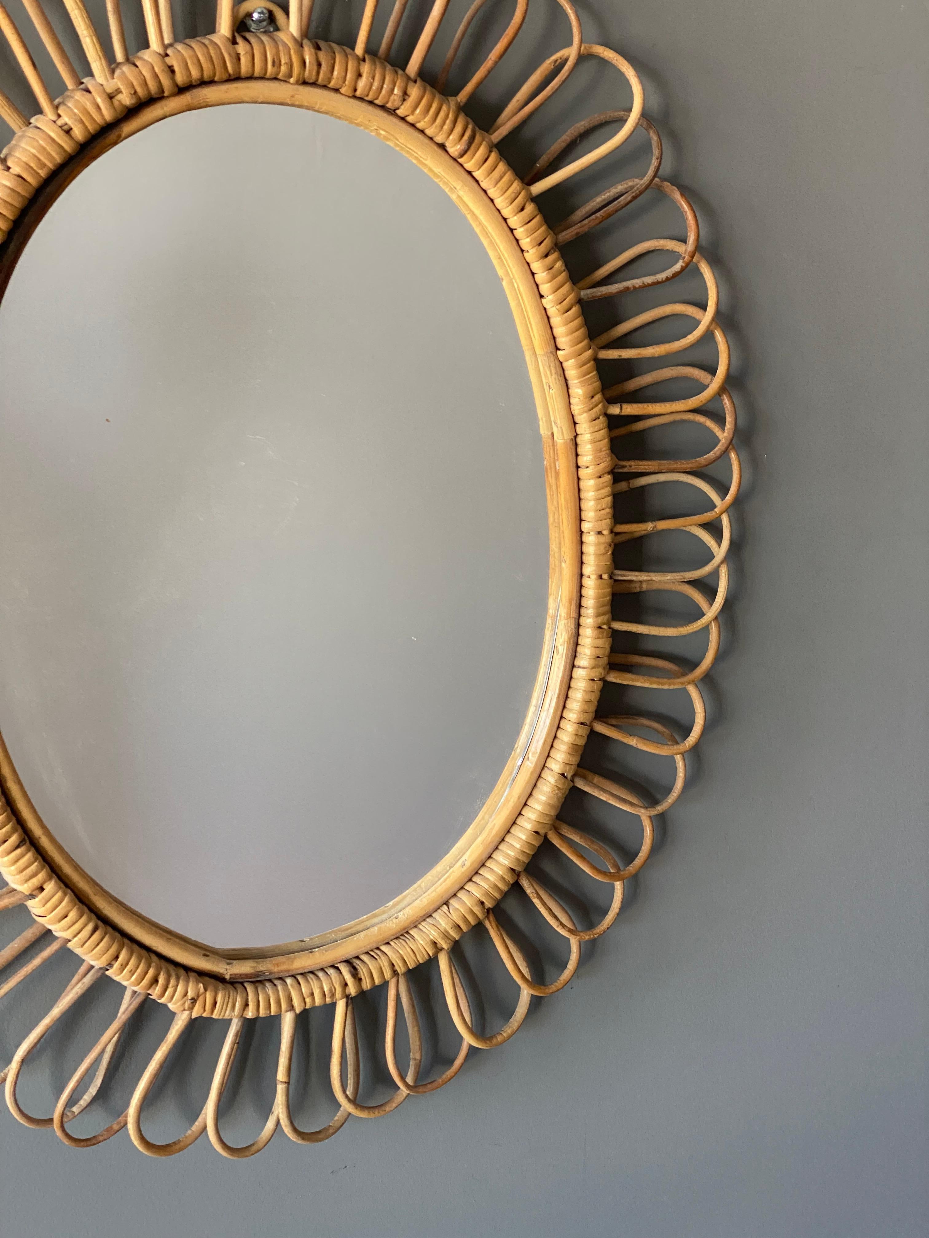A wall mirror, produced in Italy, 1950s. Cut mirror glass is framed in bamboo and rattan.

 