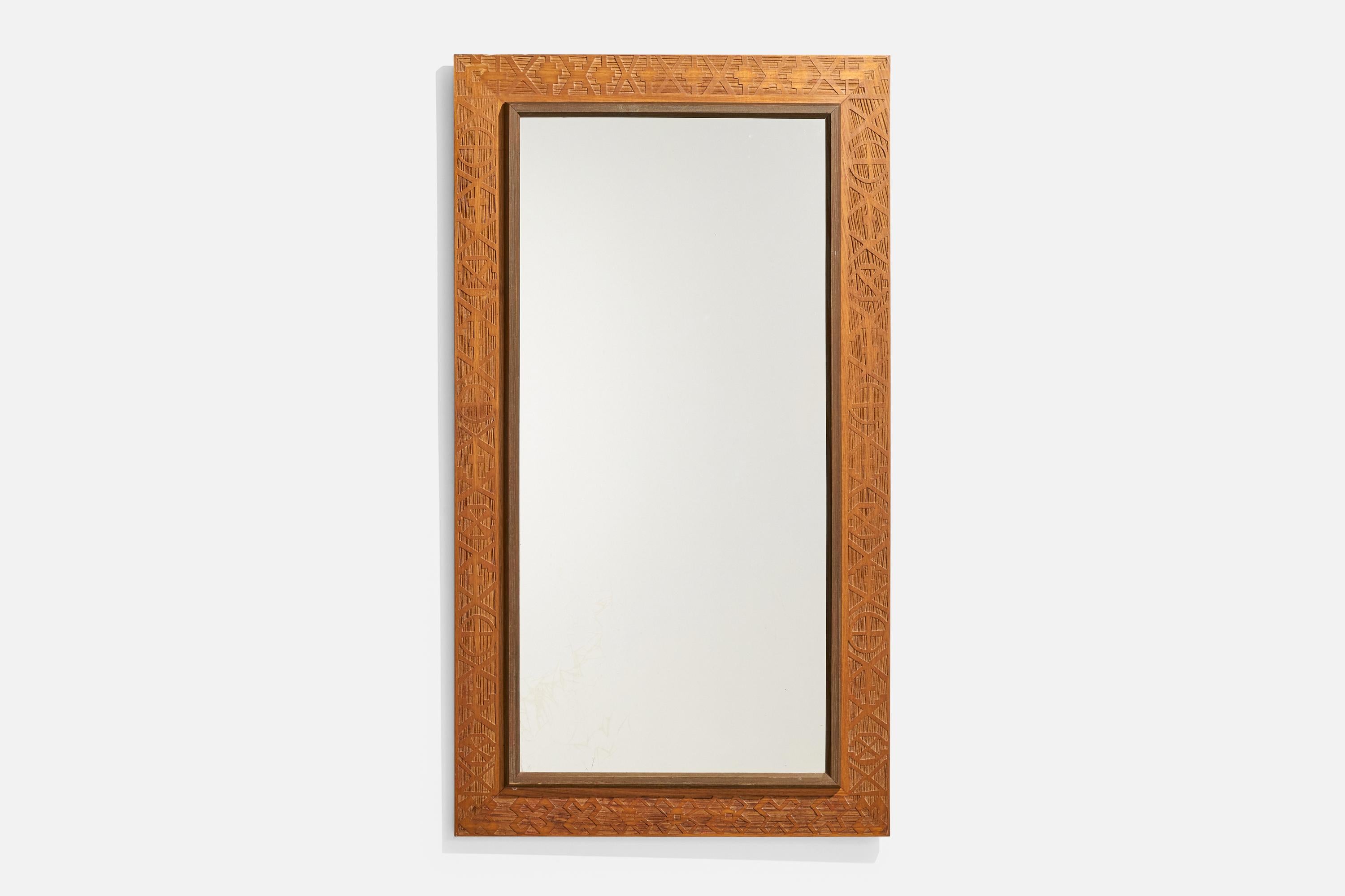 Specchio da parete in legno intagliato progettato e prodotto in Italia, anni '30 circa.
 