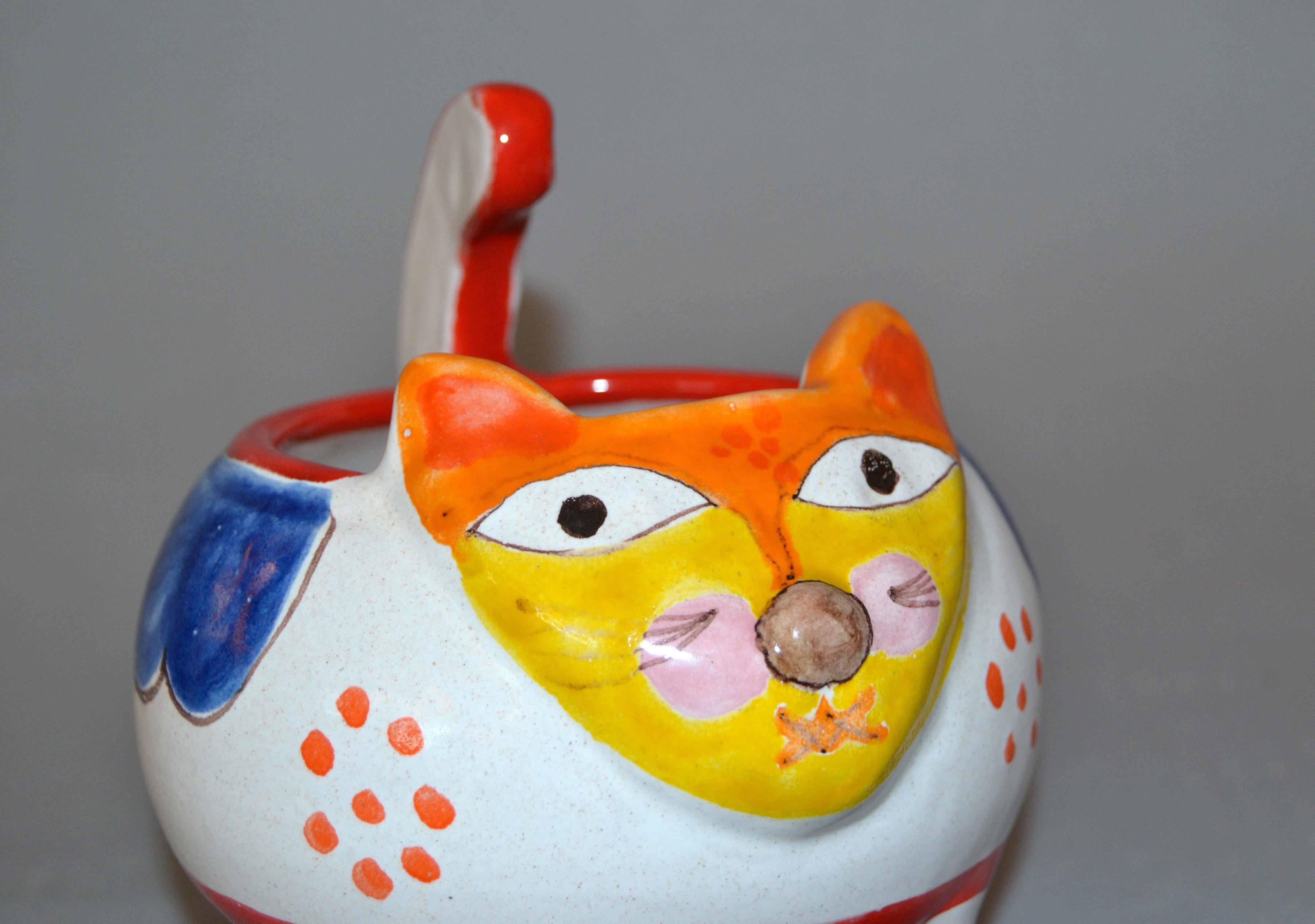 A glazed and colorful DeSimone hand painted art pottery cat bowl from Italy made for Gump's.
The painting on the bowl depicts a cat. 
The bowl is 6.5 inches high and 5.5 inches deep by 6.0 inches wide.
It is in excellent condition with no chips