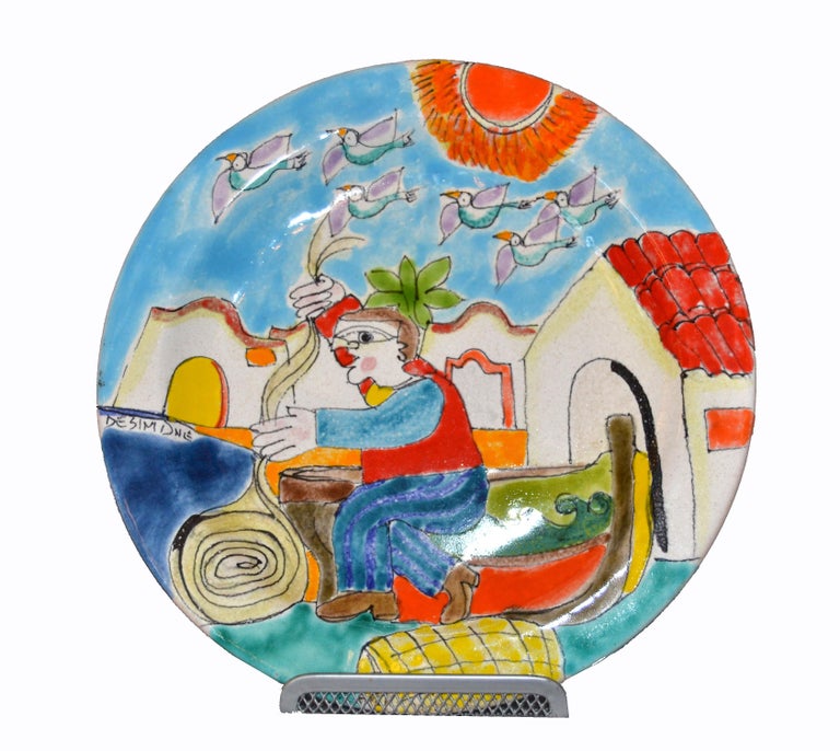 Original Italian Giovanni Desimone hand painted art pottery, round decor plate depicts a scene of a fisherman folding his fish casting nets on a sunny day in front of his house.
Birds are flying in the air.
The plate is glazed and very