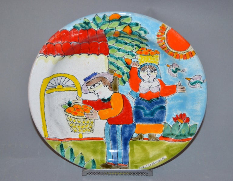 Original Italian Giovanni Desimone hand painted art pottery, round decor plate depicts a scene of a man and a woman picking Oranges.
The plate is glazed and very colorful.
Makers Mark on the plate as well as marked and numbered on underside,