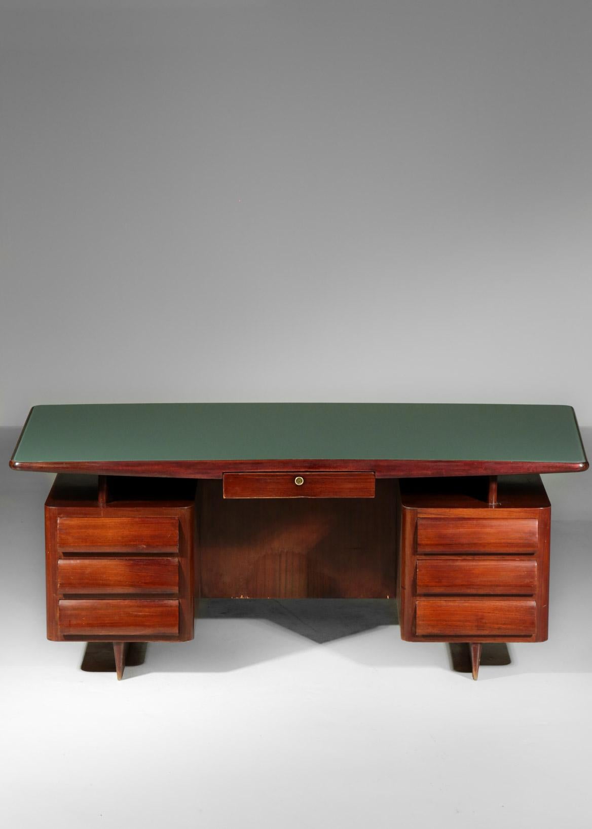 Desk designed by Vittorio Dassi and composed of a floating top with a green glass supported by 2 drawers on each side, made in walnut.