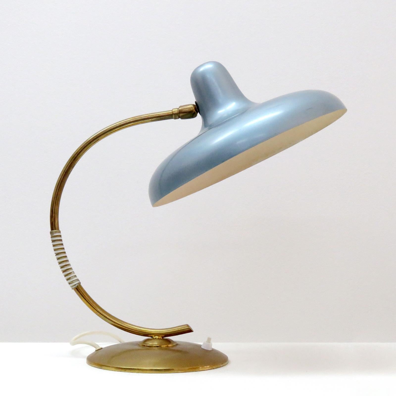 Elegant Italian desk lamp in style of Stilnovo with a large organically shaped pivoting shade, enameled in a blueish metal finish on a circular brass arm and base.