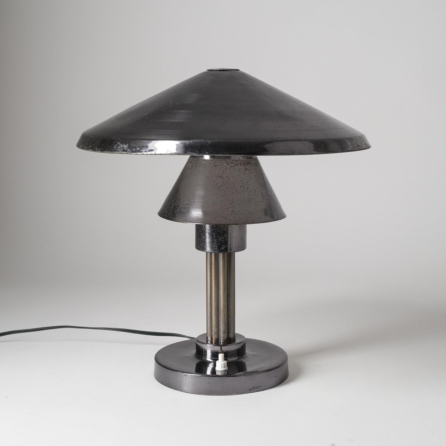 Seltene italienische Tisch- oder Schreibtischlampe aus den 1950er Jahren. Dunkel patinierte, vernickelte Messingbeschläge mit einem abgestuften Lampenschirm, der die Lichtquelle vollständig verdeckt und ein sanftes Umgebungslicht erzeugt. Eine