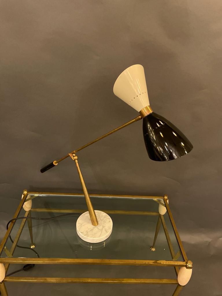 A modernist Italian desk lamp in brass with black and white shades and an elegant base in Carrara marble, in the style of Stilnovo. Circa 1970s.