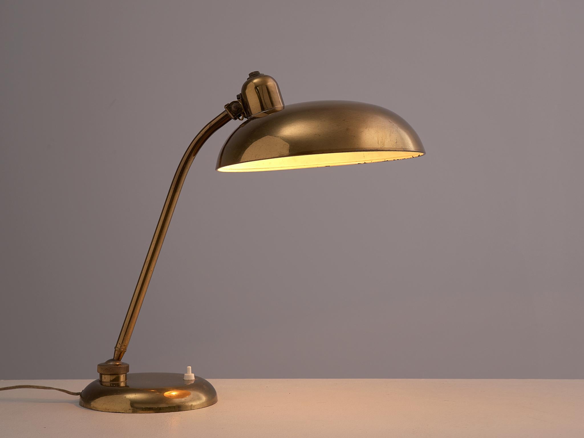 Desk light, brass, Italy, 1960s

Stylish table lamp in an admirable patinated brass. The disc-shaped shade is held up by the slim stern, which has a pivot point at the top and at the bottom for easy use. Finished with a round foot. The brass gives