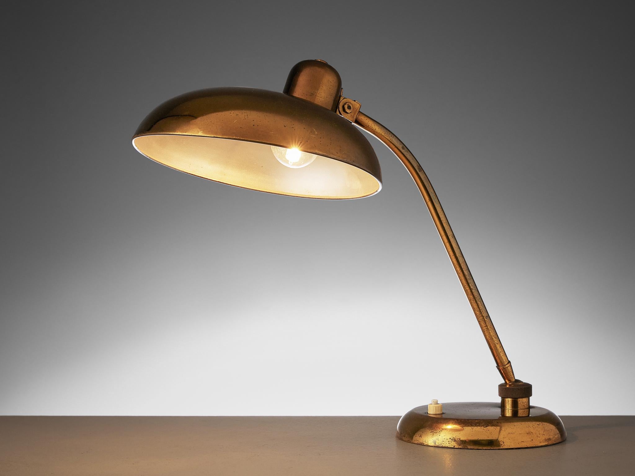 Desk light, brass, Italy, 1960s

Stylish table lamp in an admirable patinated brass. The disc-shaped shade is held up by the slim stern, which has a pivot point at the top and at the bottom for easy use. Finished with a round foot. The brass gives a