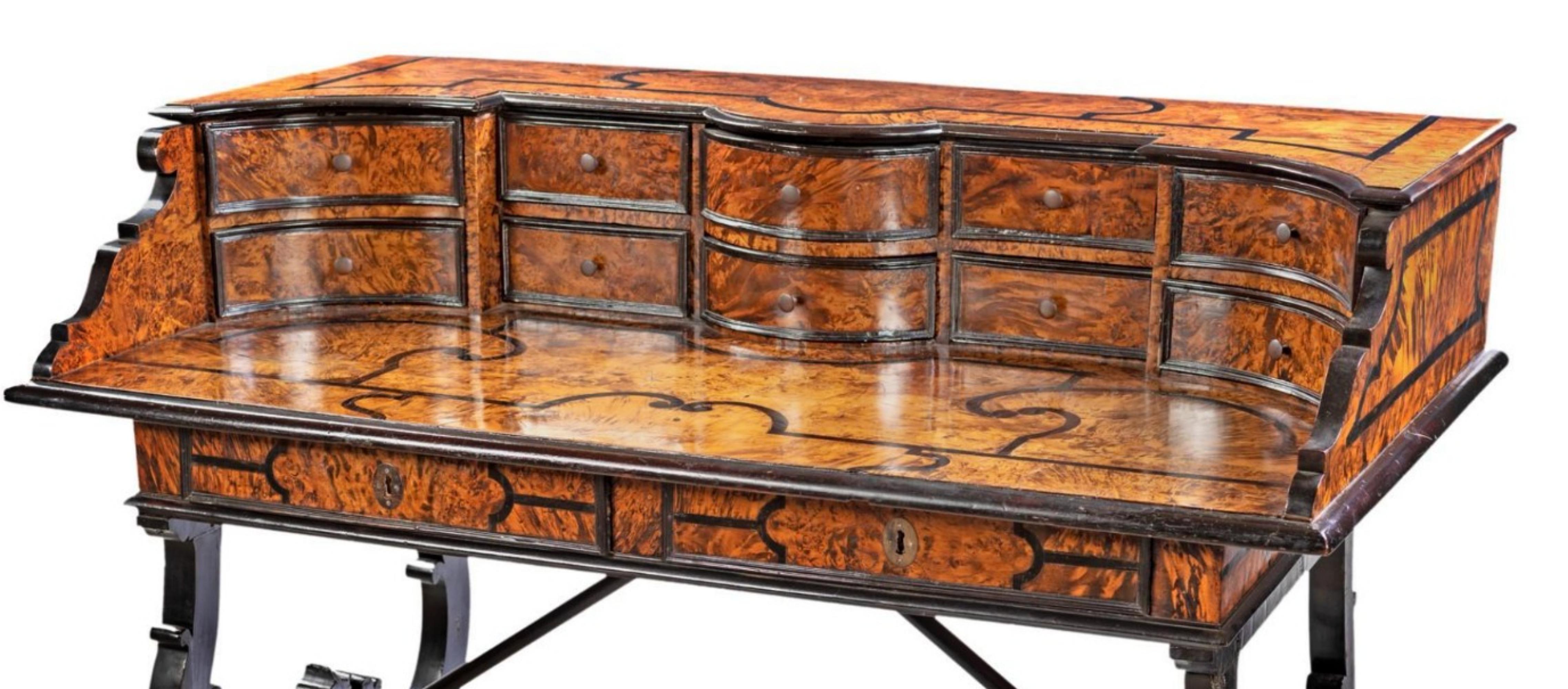 Italian Desk Veneered in Walnut Briar, Lombardy 17th century
with ebonized profiles and large contrasting threads arranged to create shaped reserves; floor surmounted by a riser with a mixtilinear facade marked by ten drawers; two drawers in line