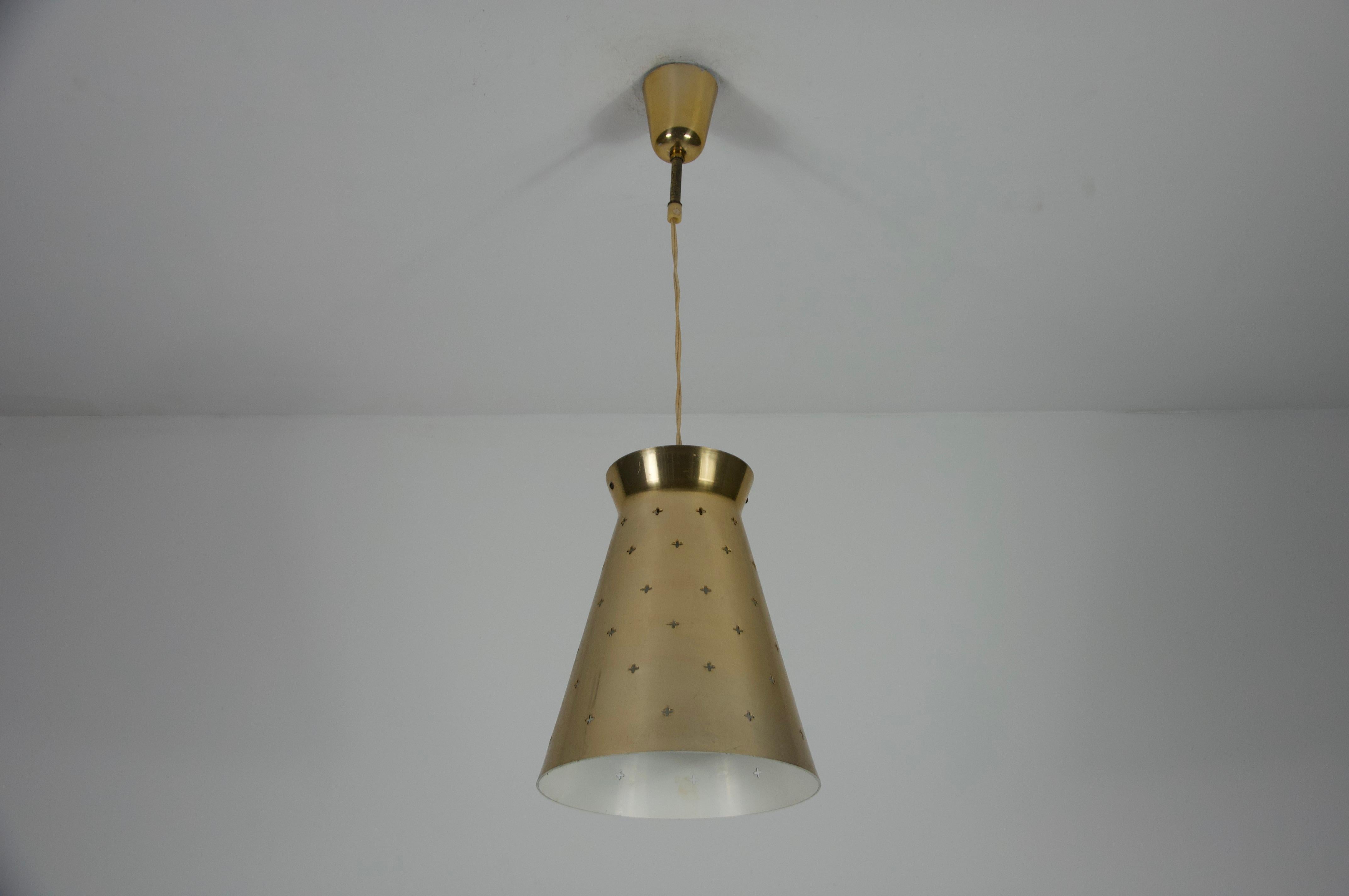 Esta asombrosa lámpara colgante italiana de los años 50 tiene la característica forma de diábolo y luce un precioso diseño de latón pulido. Con su forma cónica, esta pieza personifica el diseño moderno de mediados de siglo. Esta elegante lámpara es