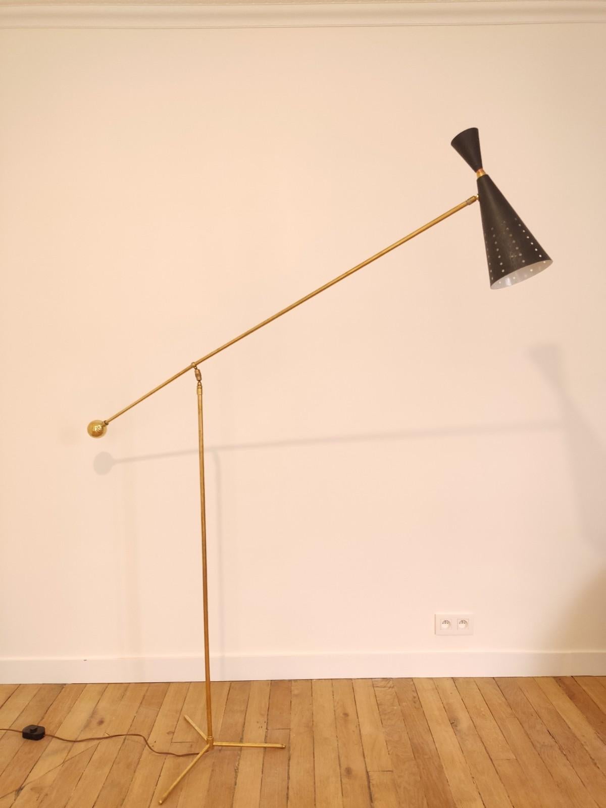 This Italian floor lamp is made in the style of Stilnovo/ Otto Kolb from the 50s.
Central brass rod with a diagonal pendulum arm finished with a black metal diabolo lampshade and white interior. Good general condition.

