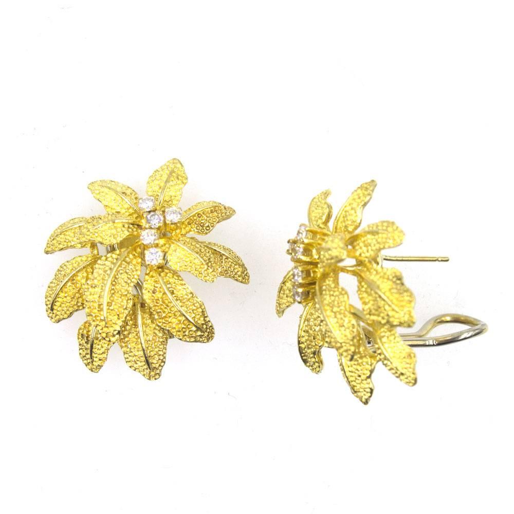 Beautiful floral earrings fashioned in textured 18 karat yellow gold. Ten diamonds shine in the center of the flowers which measure 30 x 30mm. Stamped Italy 750 and hallmarked.