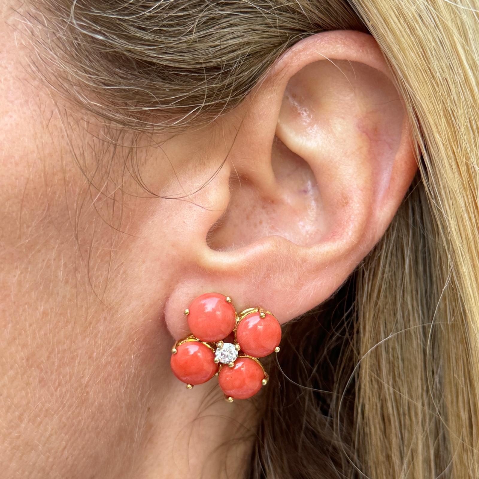 Gorgeous Italian coral and diamond floral earrings handcrafted in 18 karat yellow gold. The earrings feature 8 coral gemstones and 2 round brilliant cut diamonds weighing approximately .40 CTW. The diamonds are graded G color and VS2 clarity. The