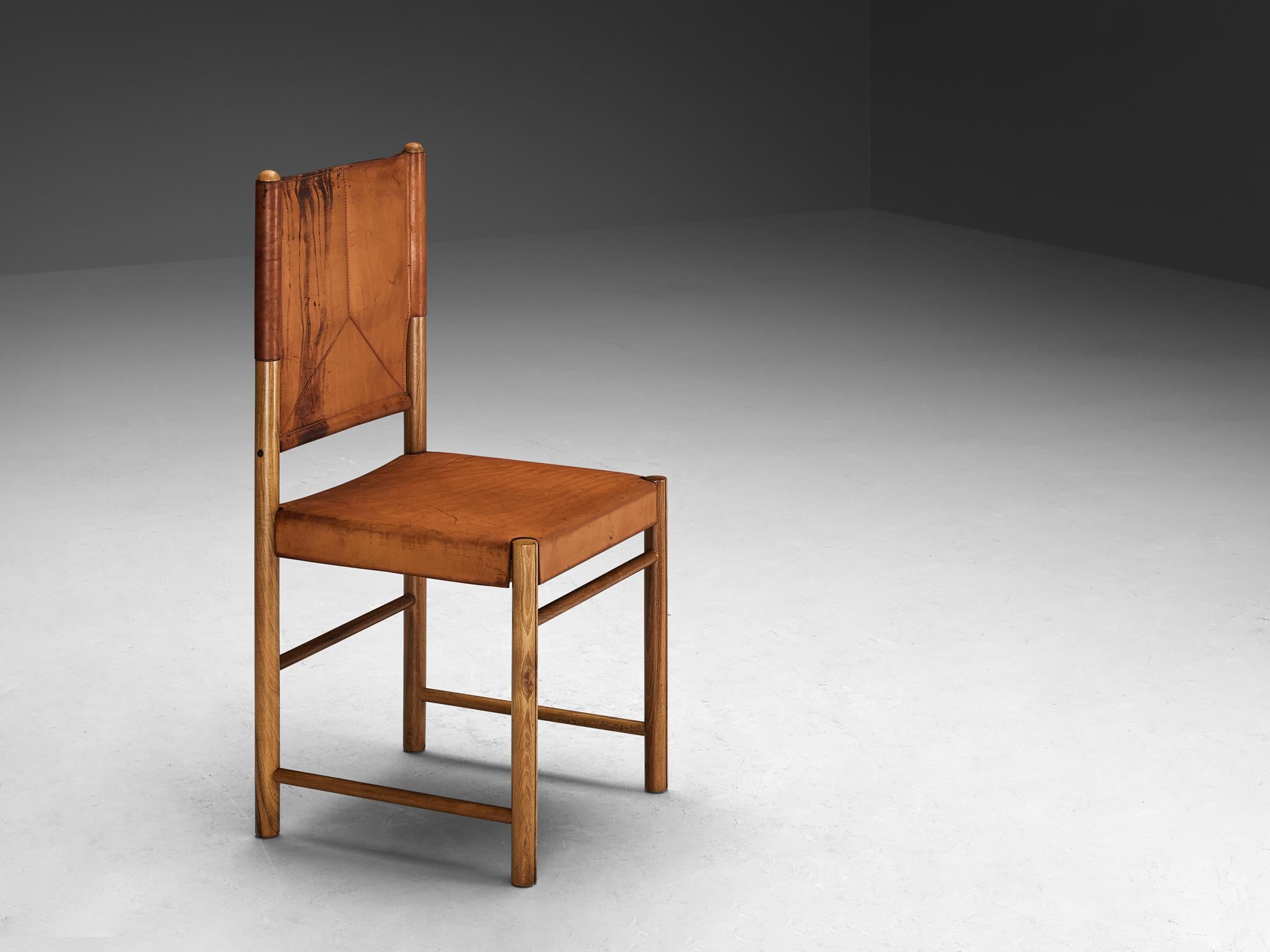 Dining chair, saddle leather, walnut, Italy, 1970s

An elegant and well-proportioned dining chair designed to elevate one's dining area with strength and vitality. Crafted with a wooden frame composed of cylindrical beams securing the leather, this