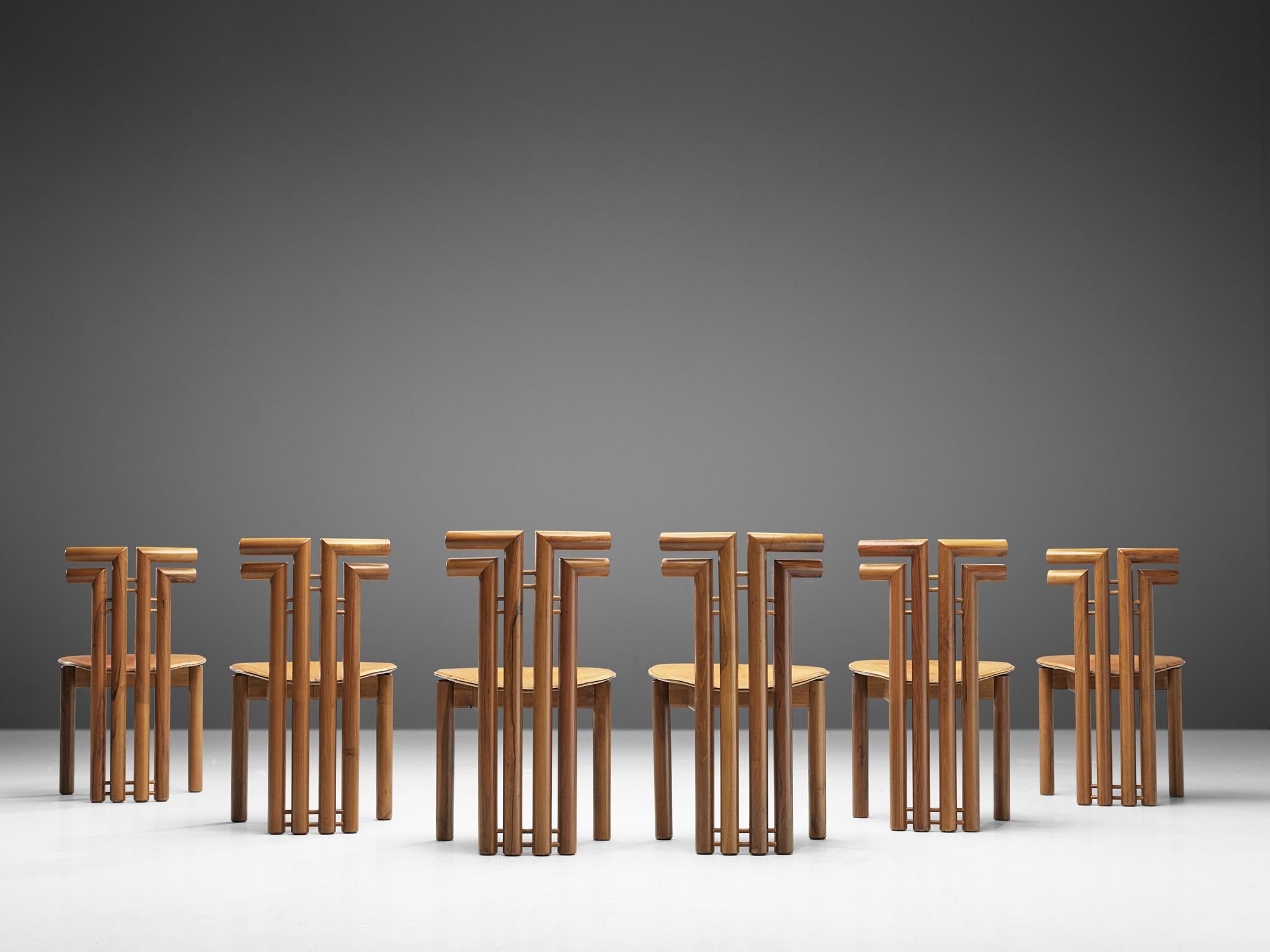 Set of dining chairs, Italian walnut and cognac leather, Italy, 1970s.

Set of six sculptural chairs that feature wonderful backrests, consisting of four round pillar like chair legs that fan out to the side, which creates a sculptural appearance.