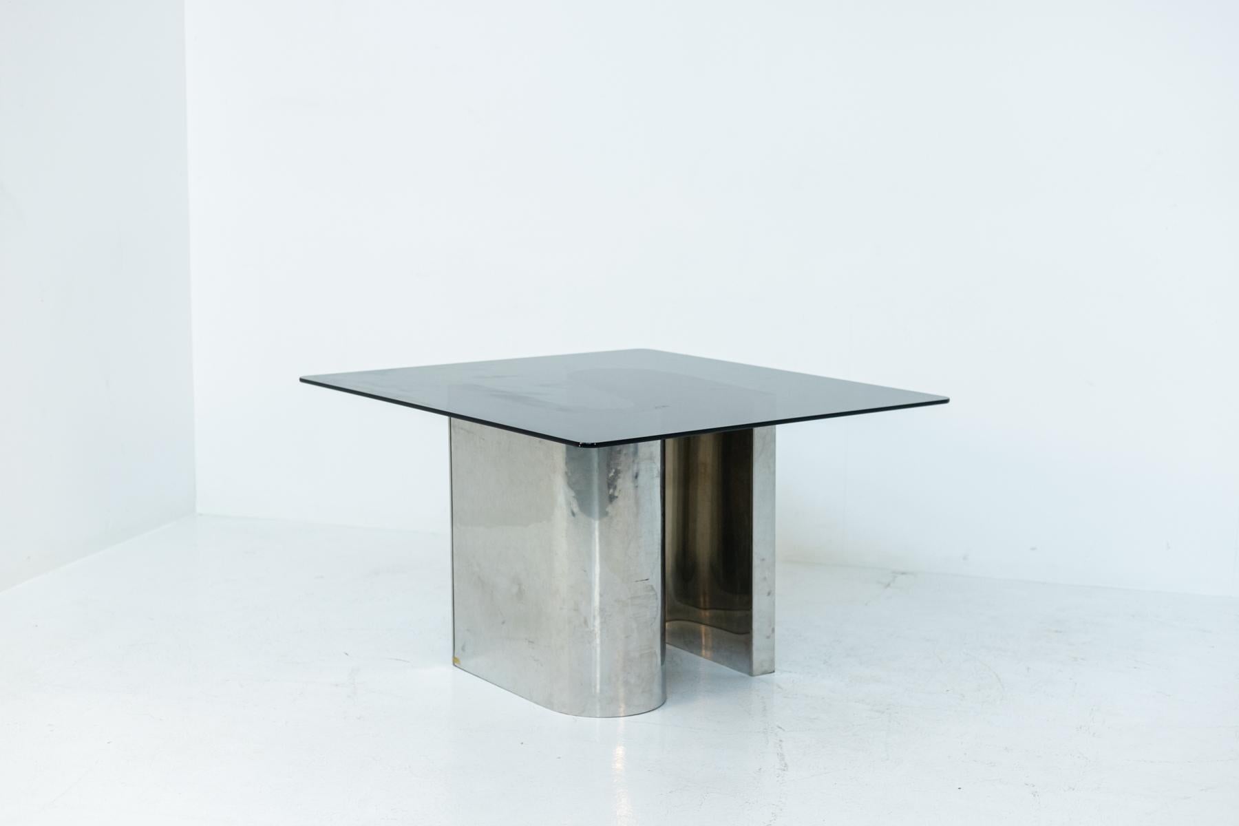 Modern 70's Italian space age dining table. The table is made of steel and glass. Its structure and base is made in the shape of S in steel that creates a playful and elegant movement, where the curves of steel give stability and importance. Its top