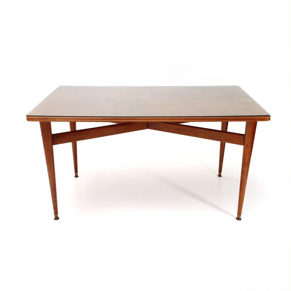 Italian manufacture table from the 1950s.
Veneered wood top with protective glass.
Conical legs in solid wood with crossbars.
Feet in brass.
Good general conditions, some signs due to normal use over time.

Dimensions: Length 151 cm - Depth 87