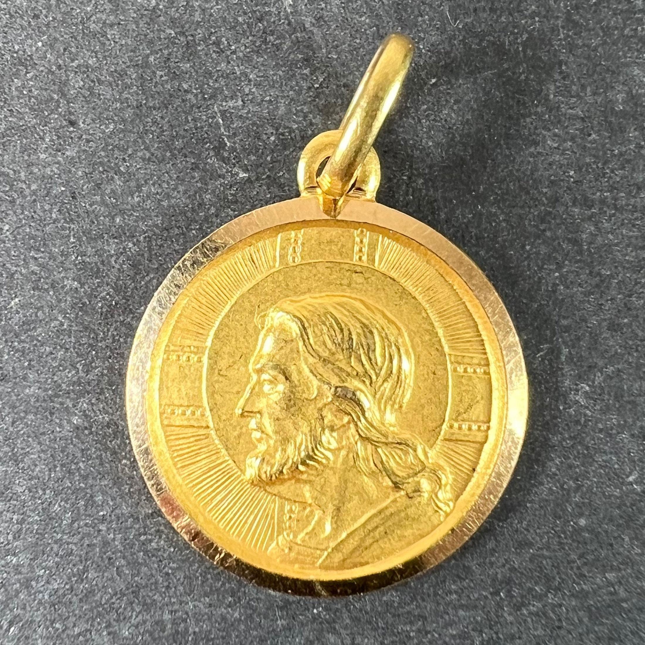 Un ciondolo italiano in oro giallo 18 carati che raffigura la testa di Gesù contro una croce su un lato e una croce e un'ancora (che indicano fede e speranza) con le parole 